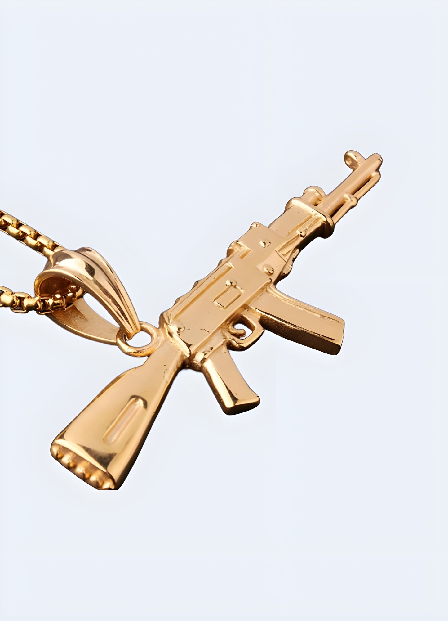 Gold AK-47 necklace featuring a detailed firearm pendant, shown from a front-side angle with a glossy finish on the chain.
