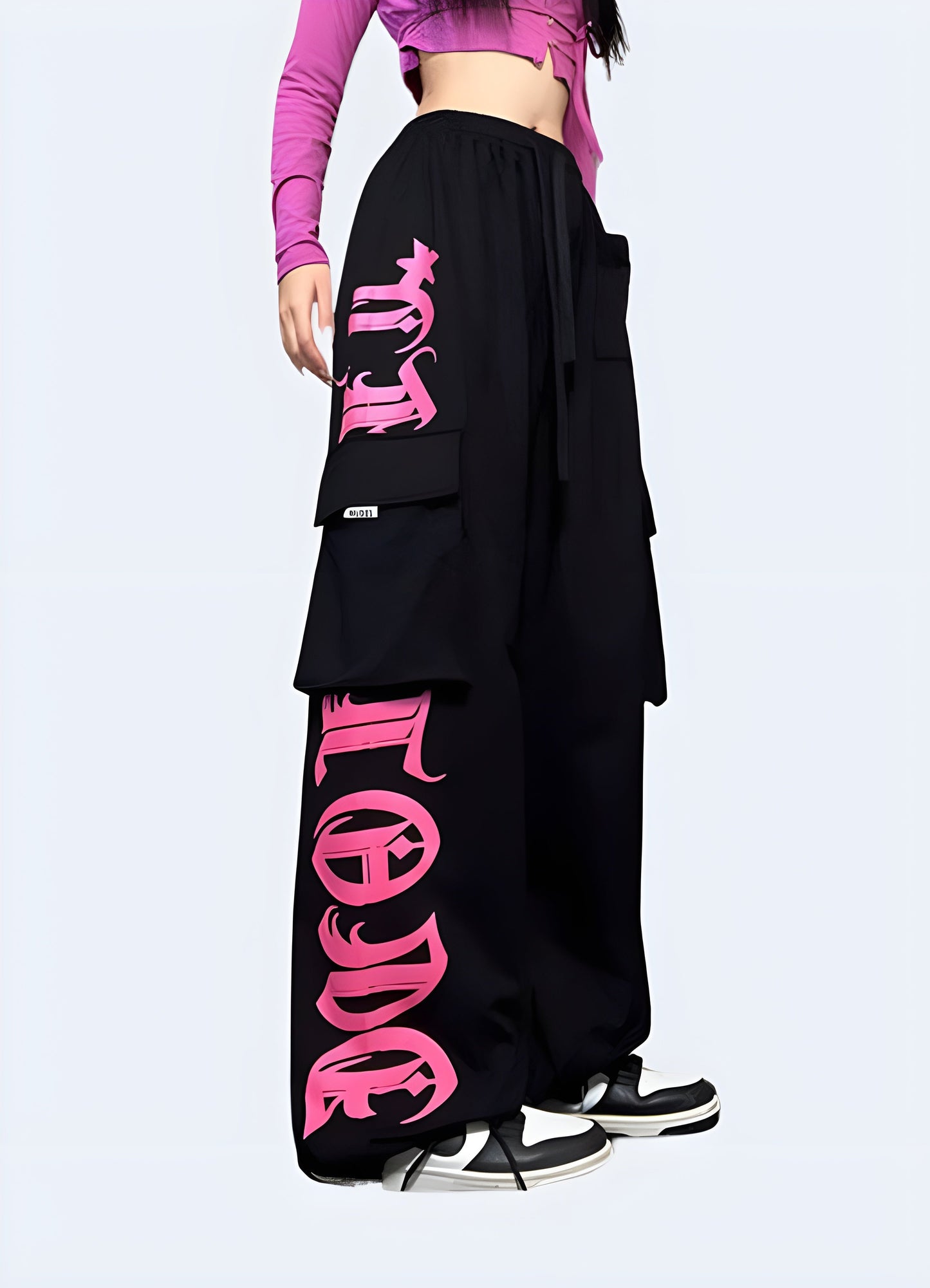 Stylish black techwear pants with contrasting pink pockets and trim, available for purchase in the Canada.