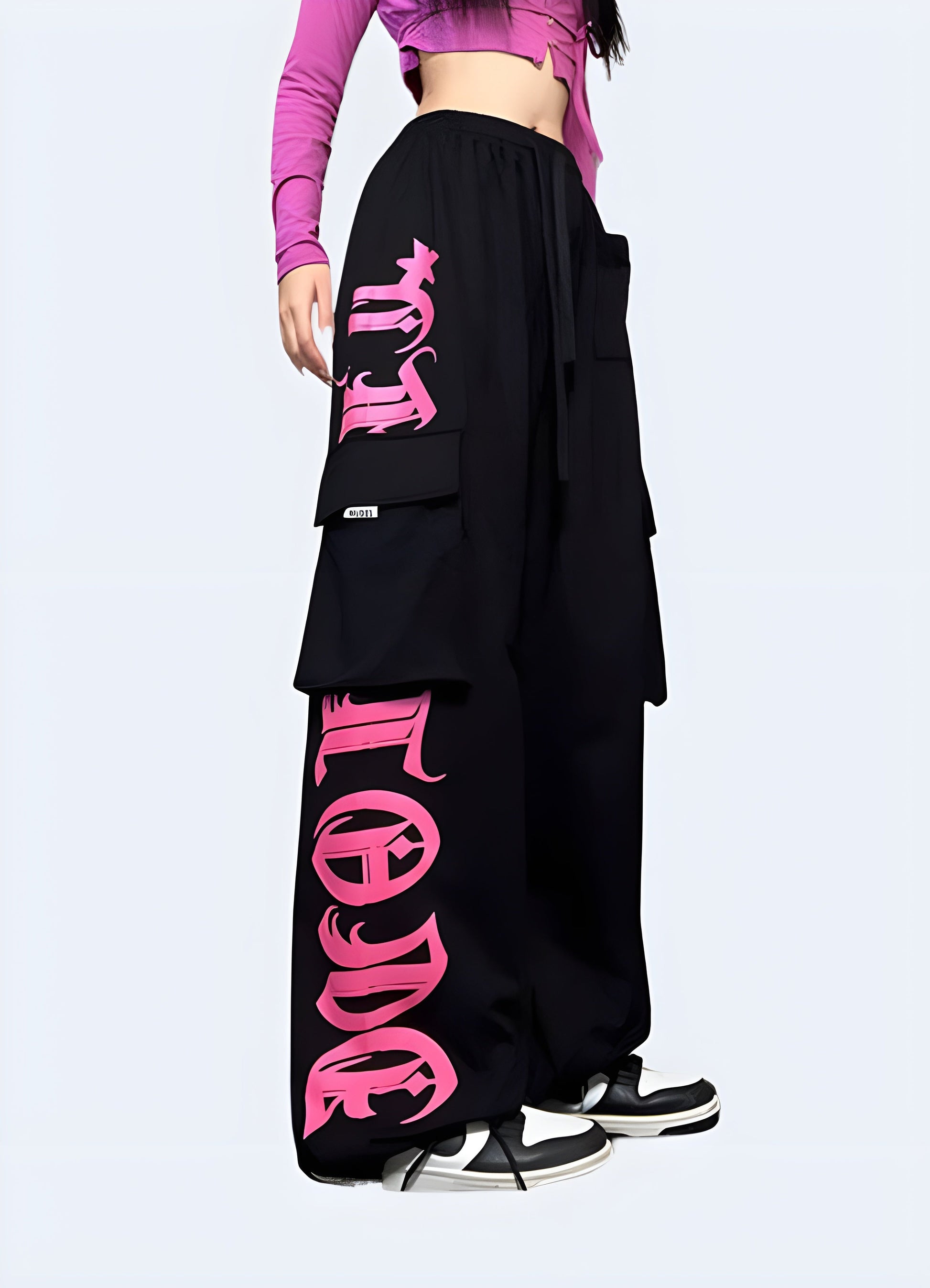 Stylish black techwear pants with contrasting pink pockets and trim, available for purchase in the Canada.