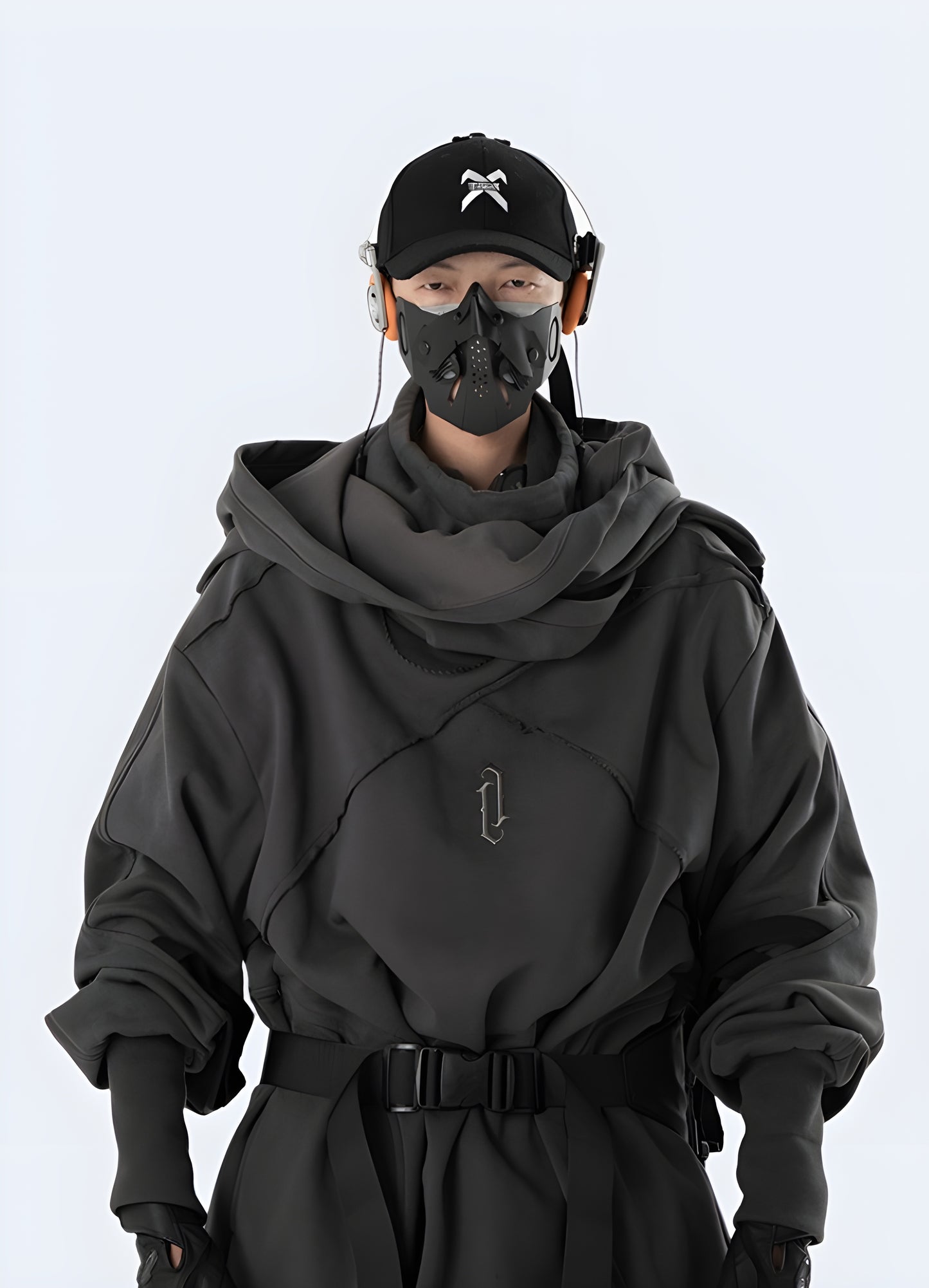 Front view of a person in a dark grey functional hoodie with various pockets, straps, and a sleek design, suitable for both outdoor activities and streetwear fashion.