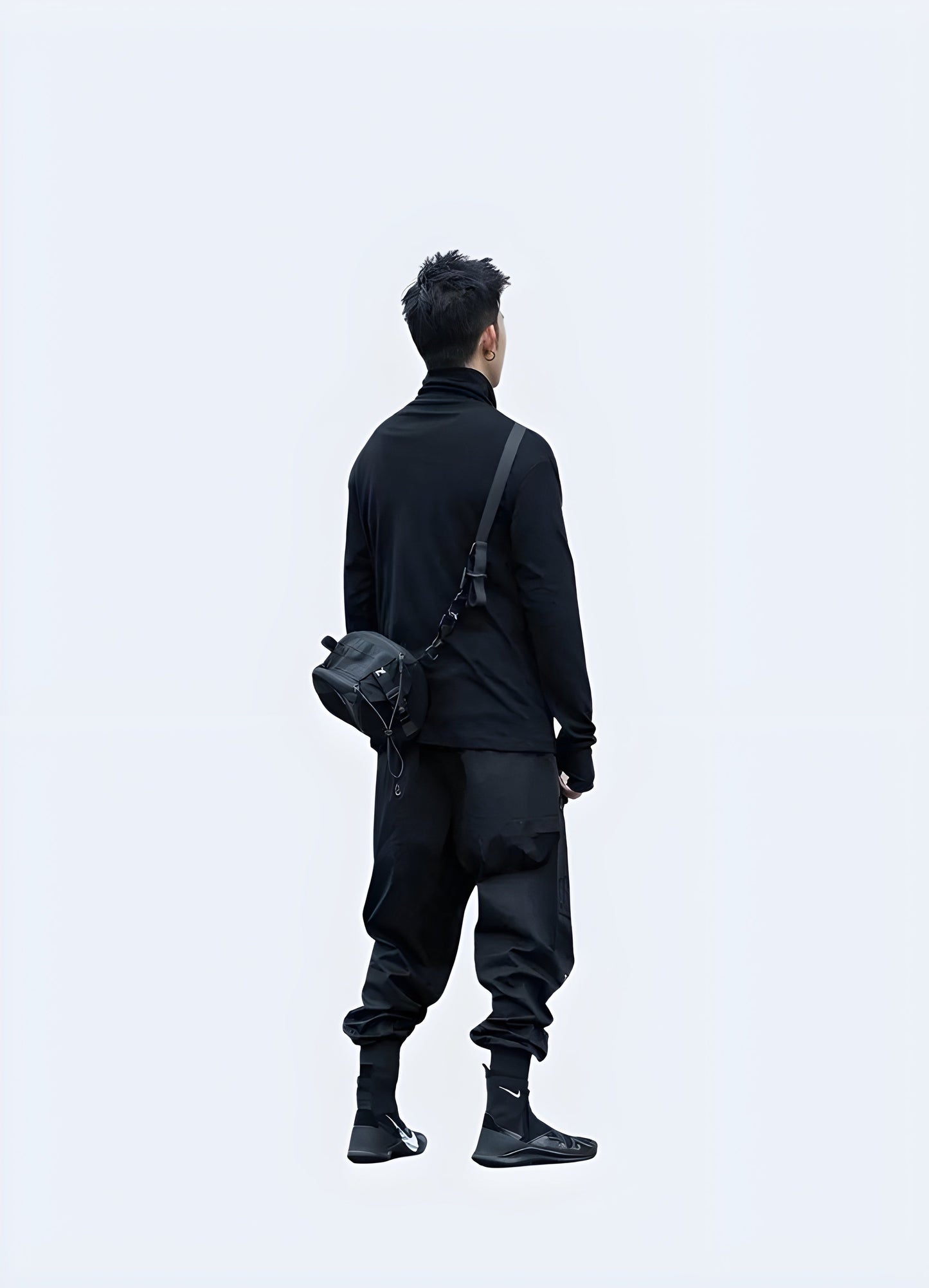 Back side view of a man sporting a techwear long sleeve shirt, highlighting its advanced materials and ergonomic fit, perfect for those who demand the best in fashion and functionality in the Canada.