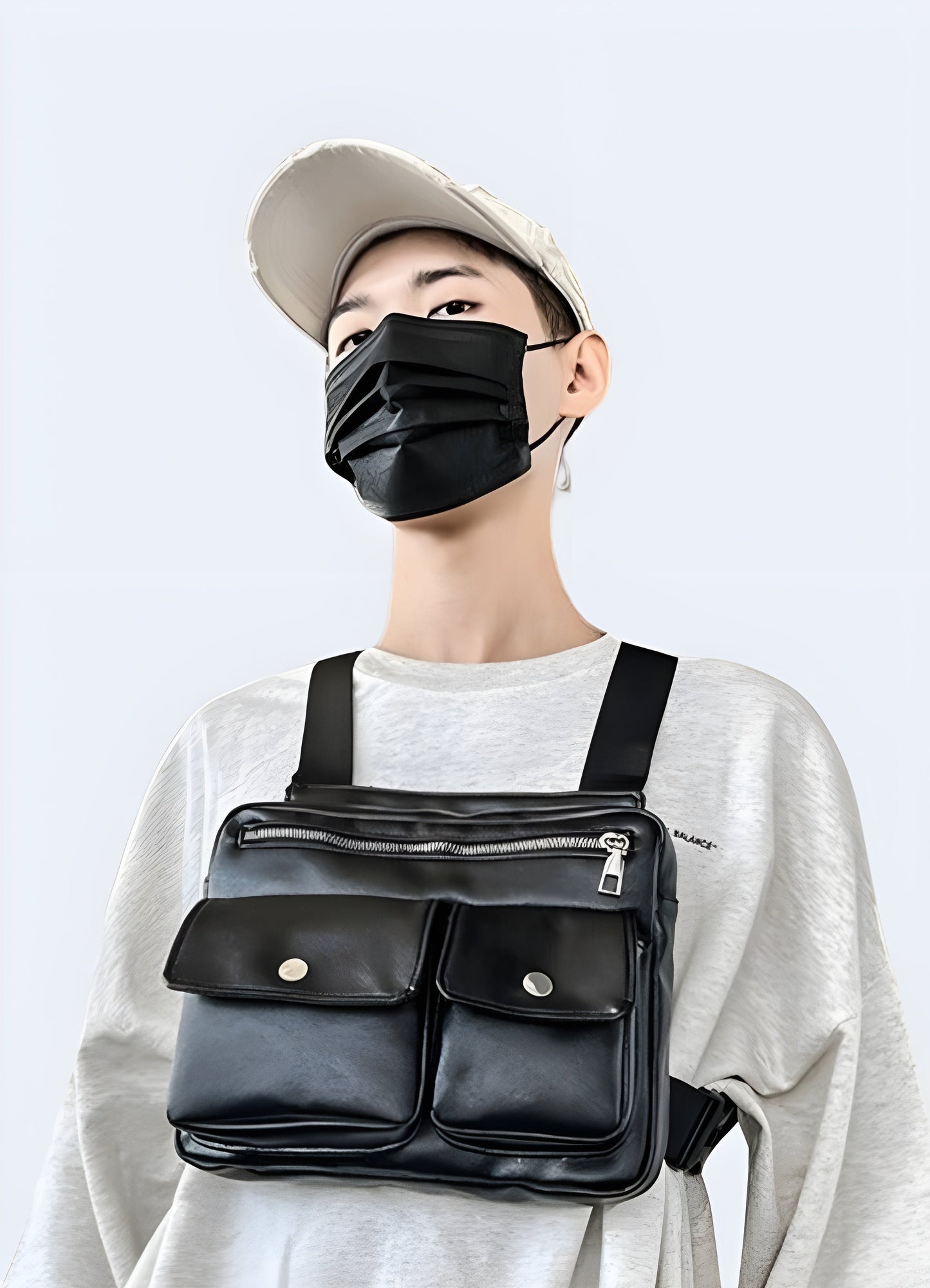 Man wearing a black leather chest bag, viewed from the front. The bag features a sleek leather finish, adjustable straps, and a minimalist design with a central compartment Canada.