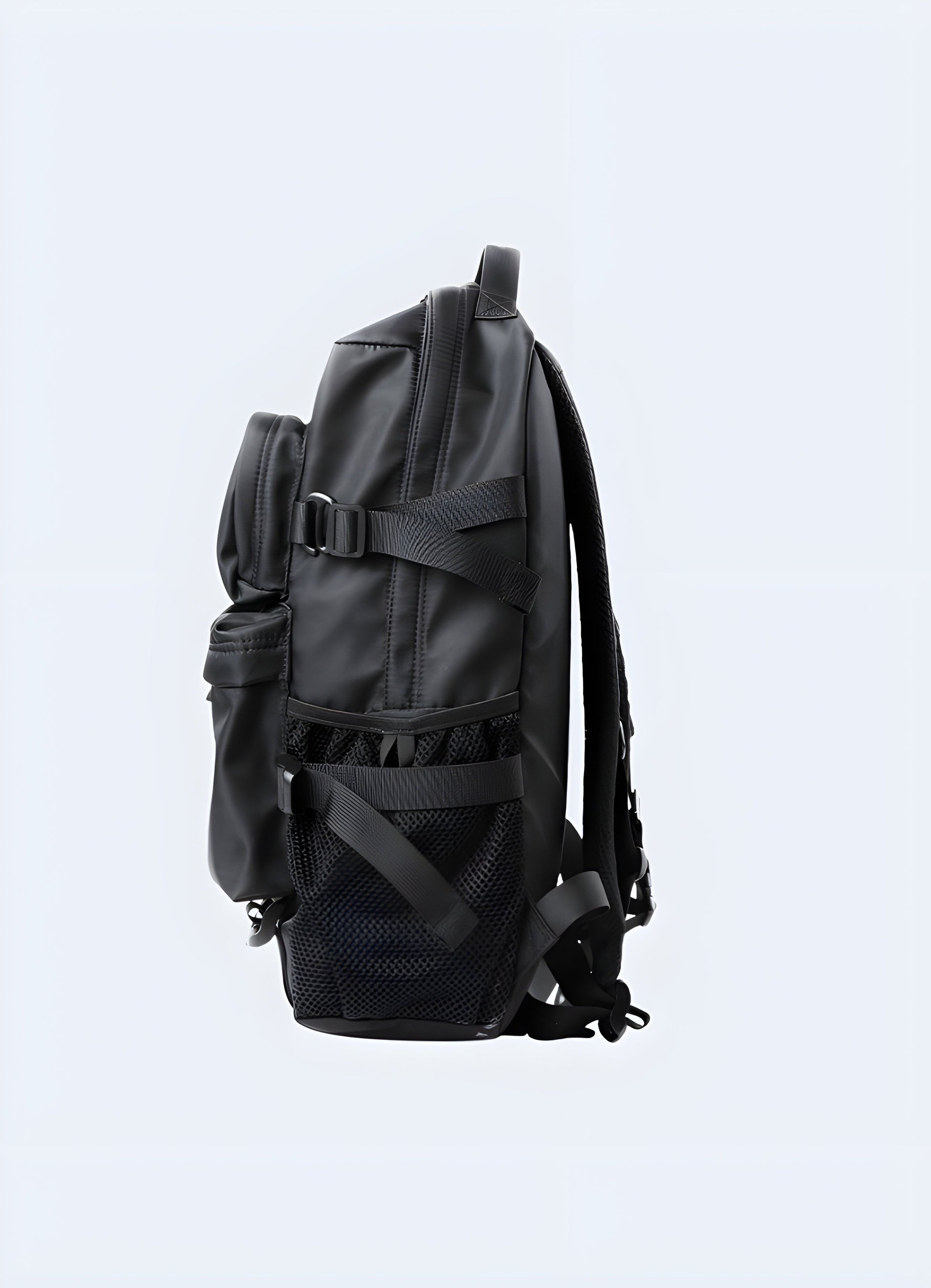 Side view of a model wearing a techwear backpack. The backpack is sleek with a matte black finish, featuring a streamlined profile and side pockets Canada.