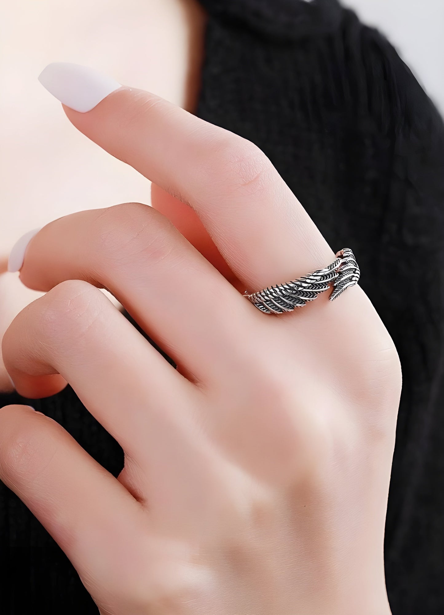 Model wearing the angel feather ring, viewed from the front and side, illustrating how the ring complements the wearer's hand.