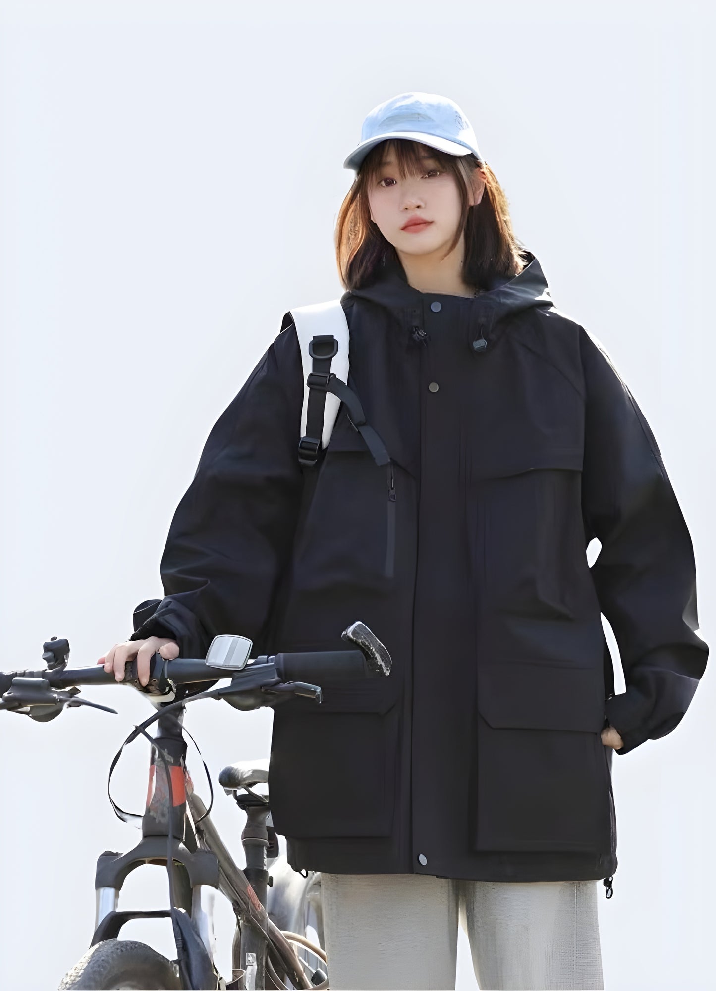 Model wearing a black hooded cargo jacket with a sleek, functional design and advanced features, ideal for expressing personal style while navigating Canada's city streets in comfort and practicality.