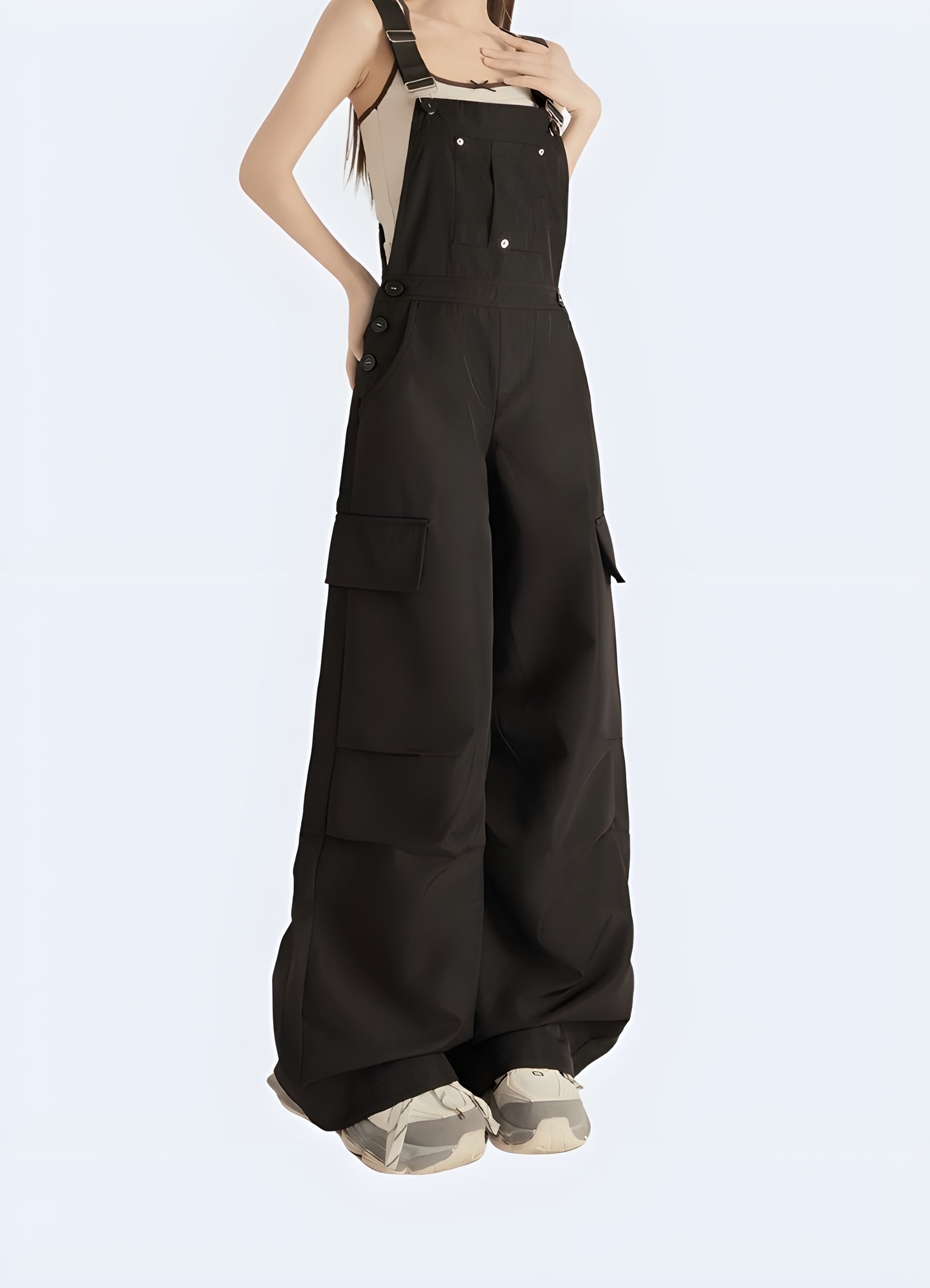 Front-side view of a woman wearing sleek black techwear overalls with tactical details and adjustable straps, captured in an urban setting in Canada.