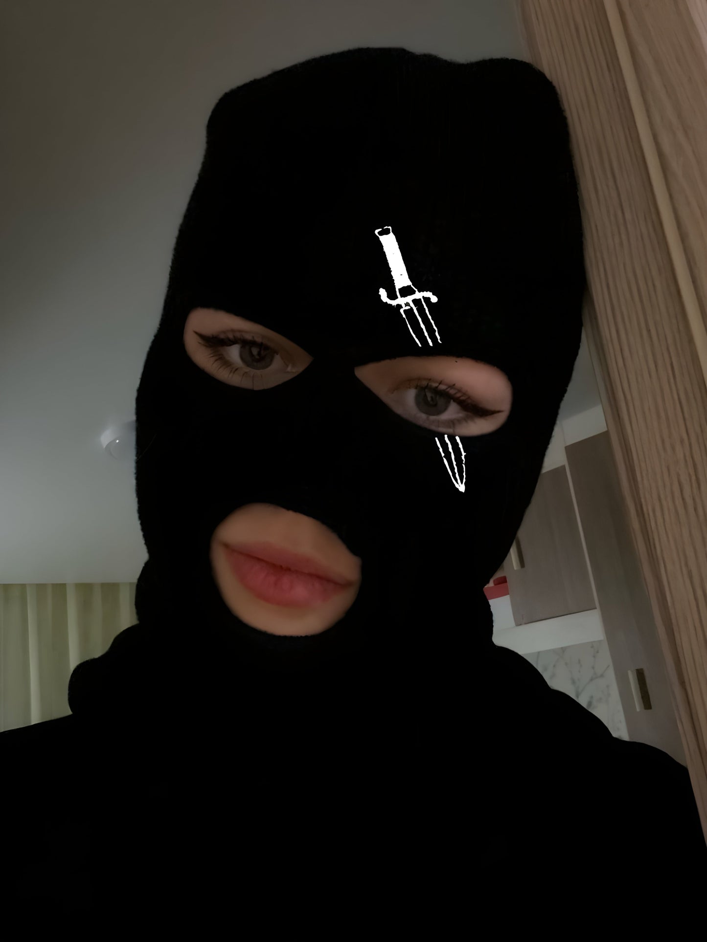 A woman wearing a balaclava, viewed from the front, with the facial features and eye area visible through the mask, emphasizing the snug fit and protective design.
