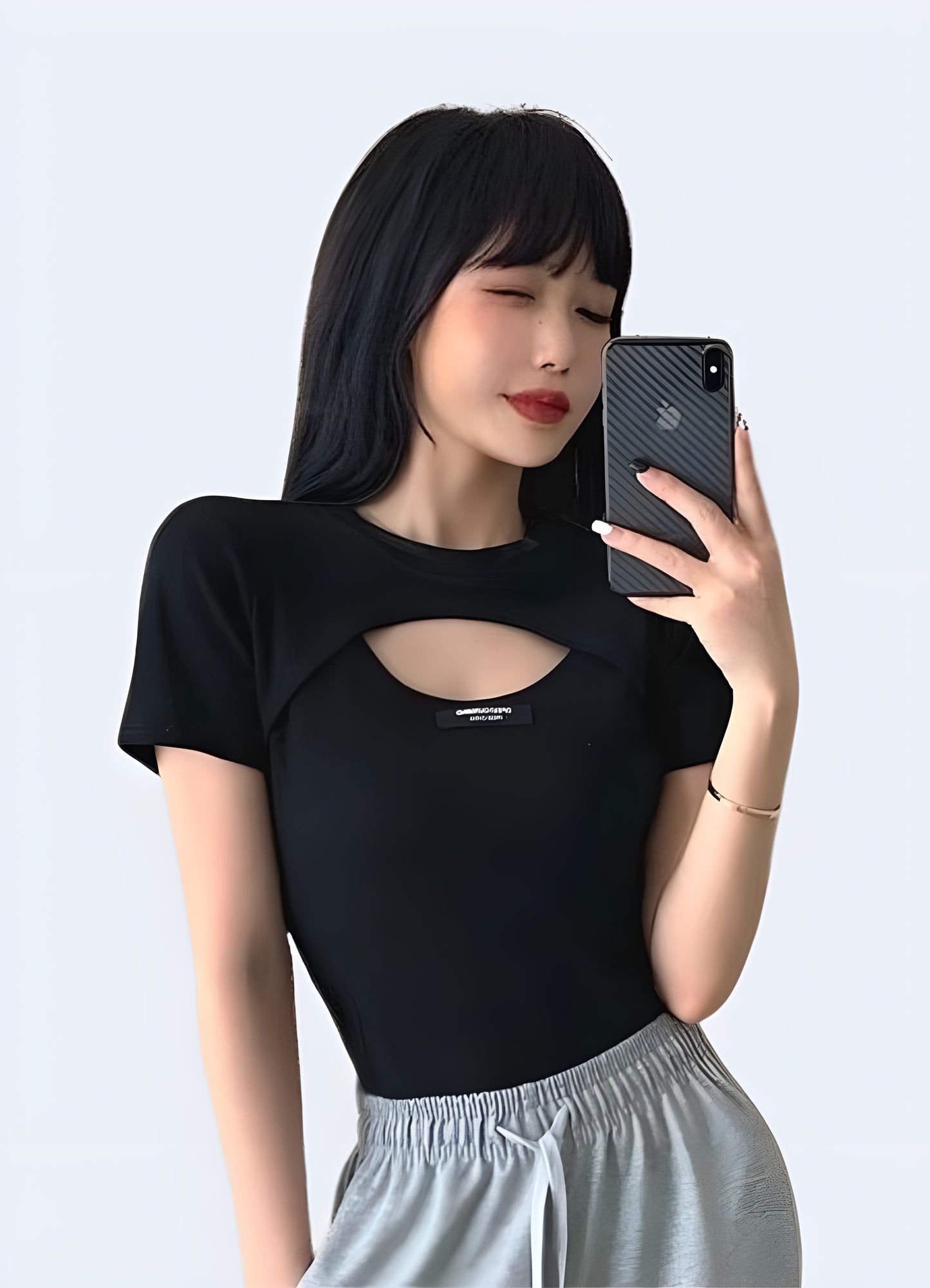 Front view of a woman wearing a stylish techwear loop crop top, highlighting contemporary urban style in Canada.