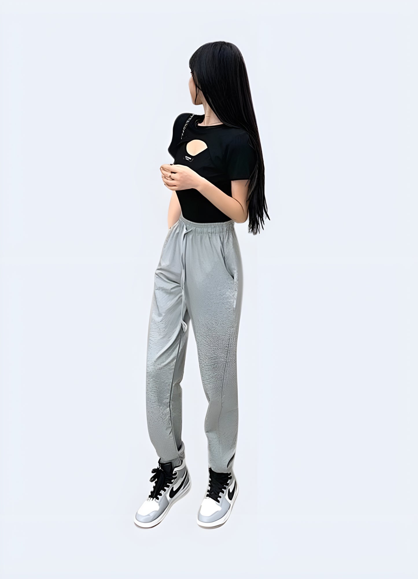 A side view of a woman wearing a techwear buckle crop top, showcasing her eye-catching buckles and modern silhouette for fashion forward women in Canada.