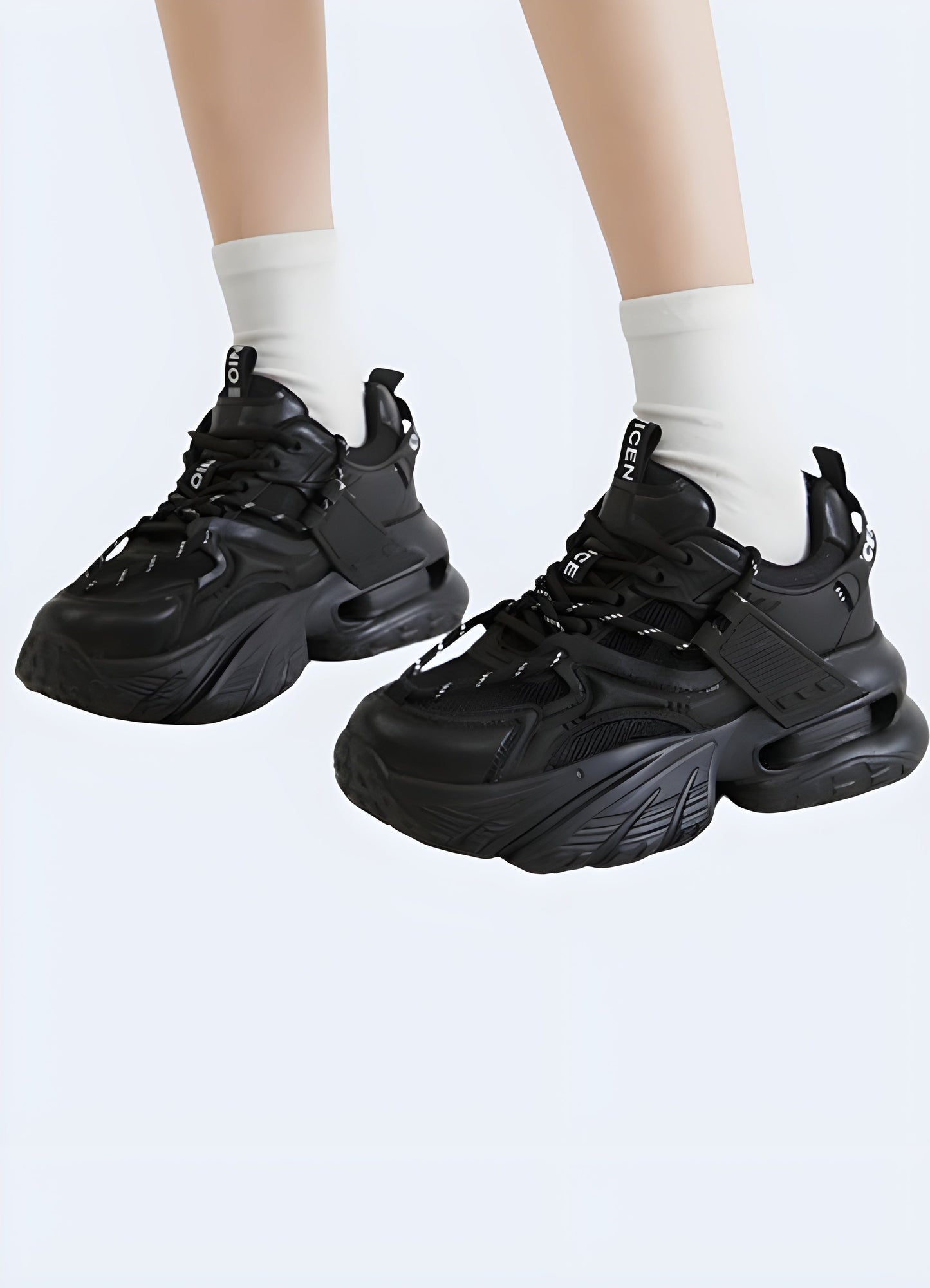 A model poses wearing chunky techwear shoes designed for women. The shoes feature a bold, futuristic design with a thick sole, offering both style and functionality.