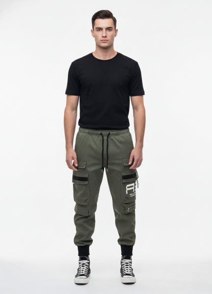 Front view of a man wearing khaki techwear cargo pants with multiple pockets and black detailing, paired with a black T-shirt and black high-top sneakers