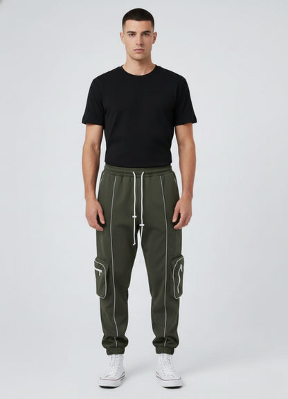 Male model wearing olive green techwear jogger pants with white reflective and side cargo pockets, paired with black tee and white sneakers.