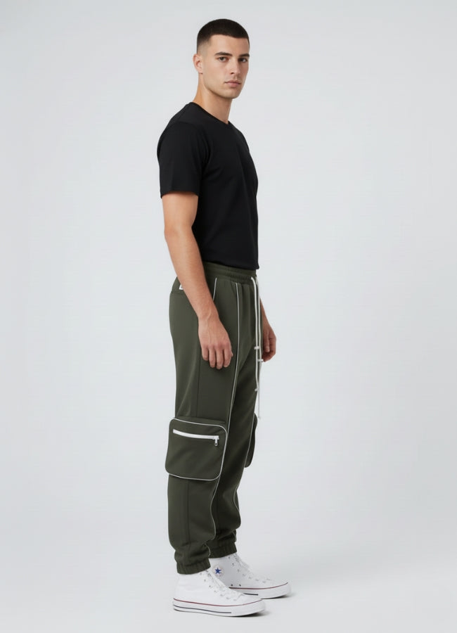Side angle of olive green techwear cargo pants showcasing sleek white reflective, large pockets, and urban tapered silhouette.