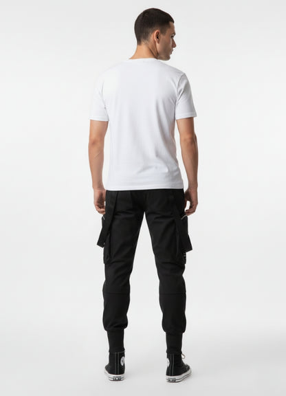 Rear view of techwear cropped pants with utility pockets and strap accents, styled with white tee and black high-top sneakers