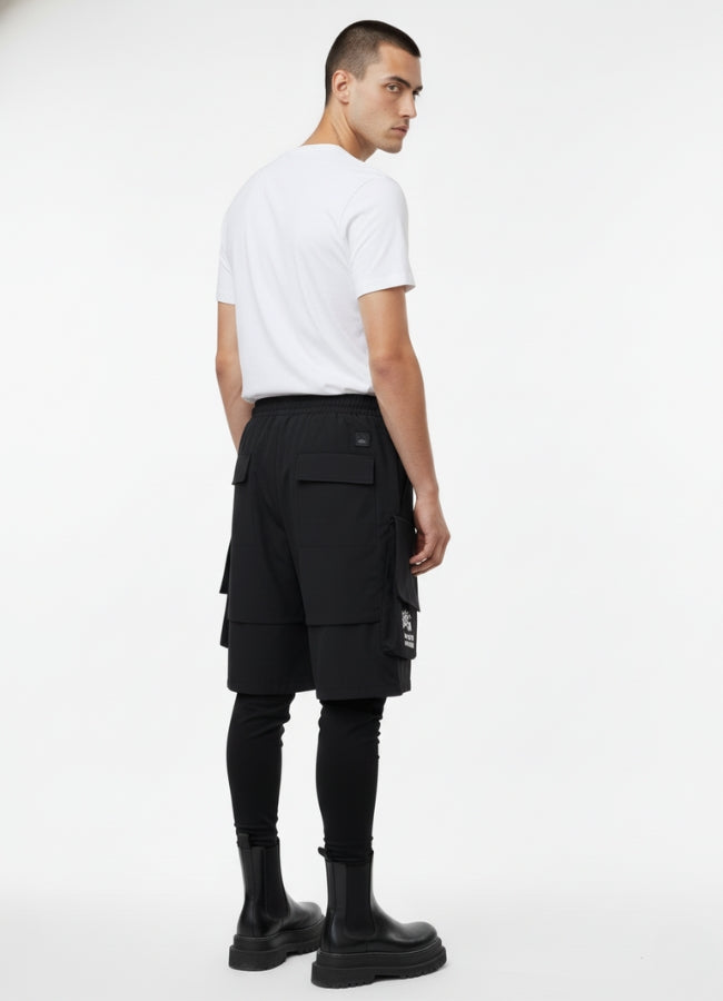 Rear view of black techwear leggings short with utility straps and back pockets, paired with black boots.