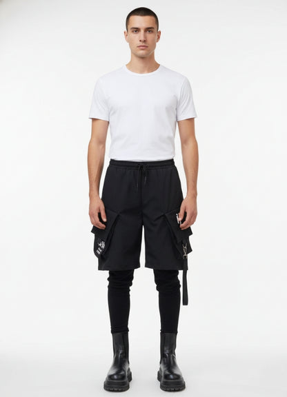 Male model wearing techwear leggings short pants, featuring oversized flap pockets and drawstring waist.
