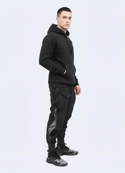 Techwear outfit featuring tactical black cargo joggers paired with hoodie and futuristic sneakers, minimalist white studio backdrop.