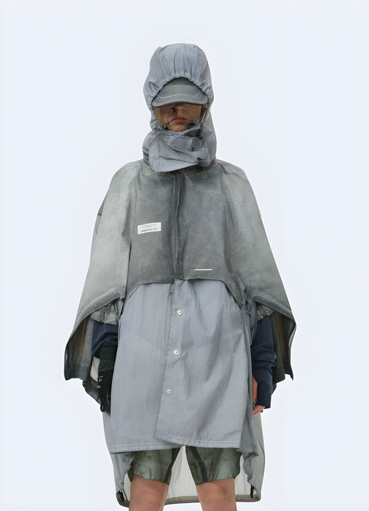 A person wearing a rugged apocalypse-style poncho in a desolate Canadian landscape, showcasing the garment's durability and functionality for survival situations.