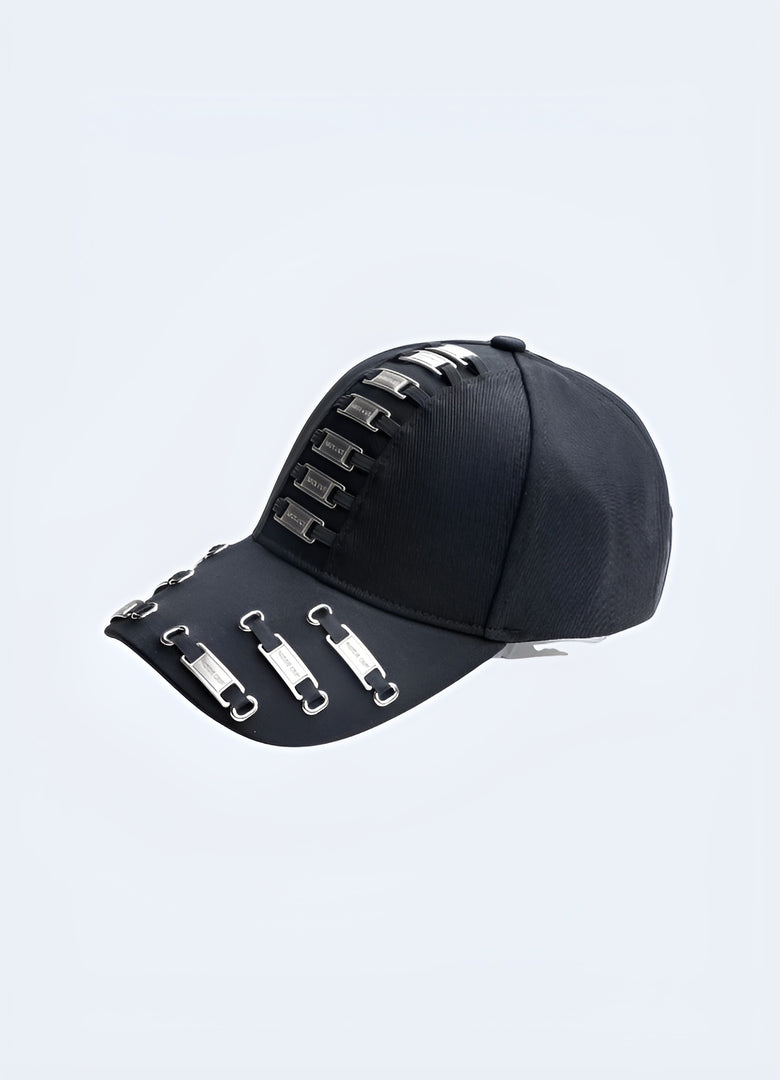 A black darkwear cap with metal frame tags, displayed from the side to show its design details. The style is inspired by Canadian street fashion trends.