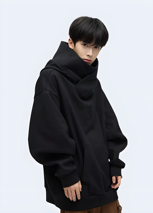 Front view of a person wearing a black Harajuku hoodie featuring a combination of different materials, numerous zippers, and an eye-catching asymmetrical cut, embodying the iconic Japanese fashion style.