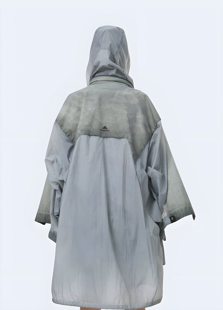 Back view of a man wearing a tough, apocalyptic poncho in a barren Canadian setting, highlighting the garment's practicality and adaptability for extreme conditions.