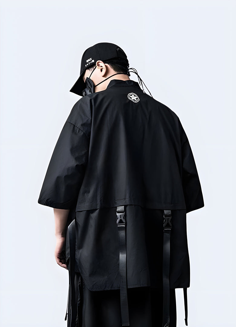 Back view of a man wearing a black techwear kimono, showcasing the unique silhouette and technical fabric, ideal for making a bold fashion statement in the UK.