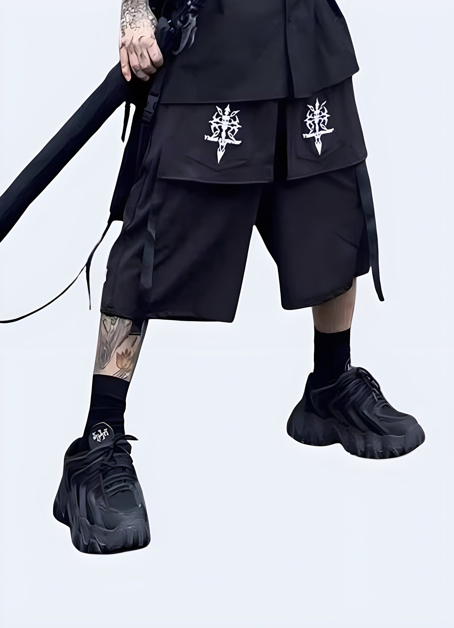 Front view of a man sporting cutting-edge darkwear shorts, showcasing the garment's black color palette, avant-garde silhouette, and meticulous craftsmanship that epitomize the darkwear fashion movement Canada.