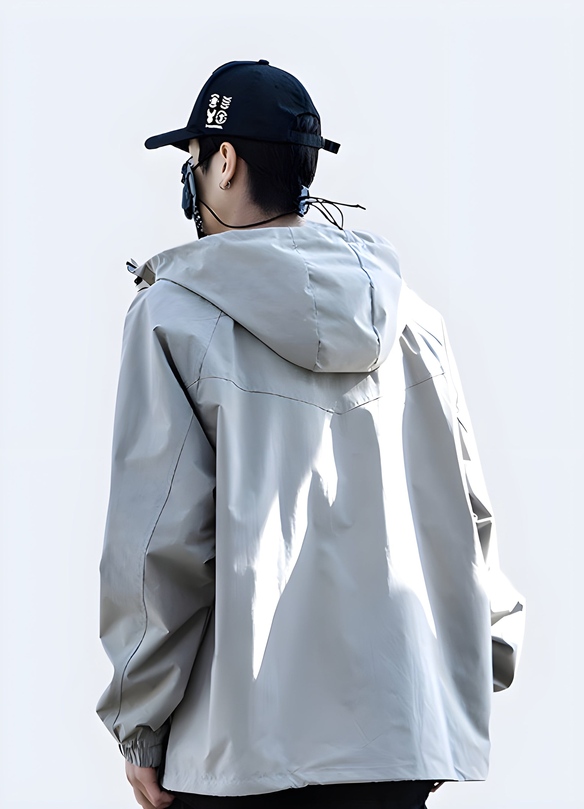 Back view of a man wearing a beige hooded cargo jacket showcasing its adjustable hood, multiple utility pockets, and durable construction, ideal for storing essentials while navigating Canada's urban landscapes in comfort and style.