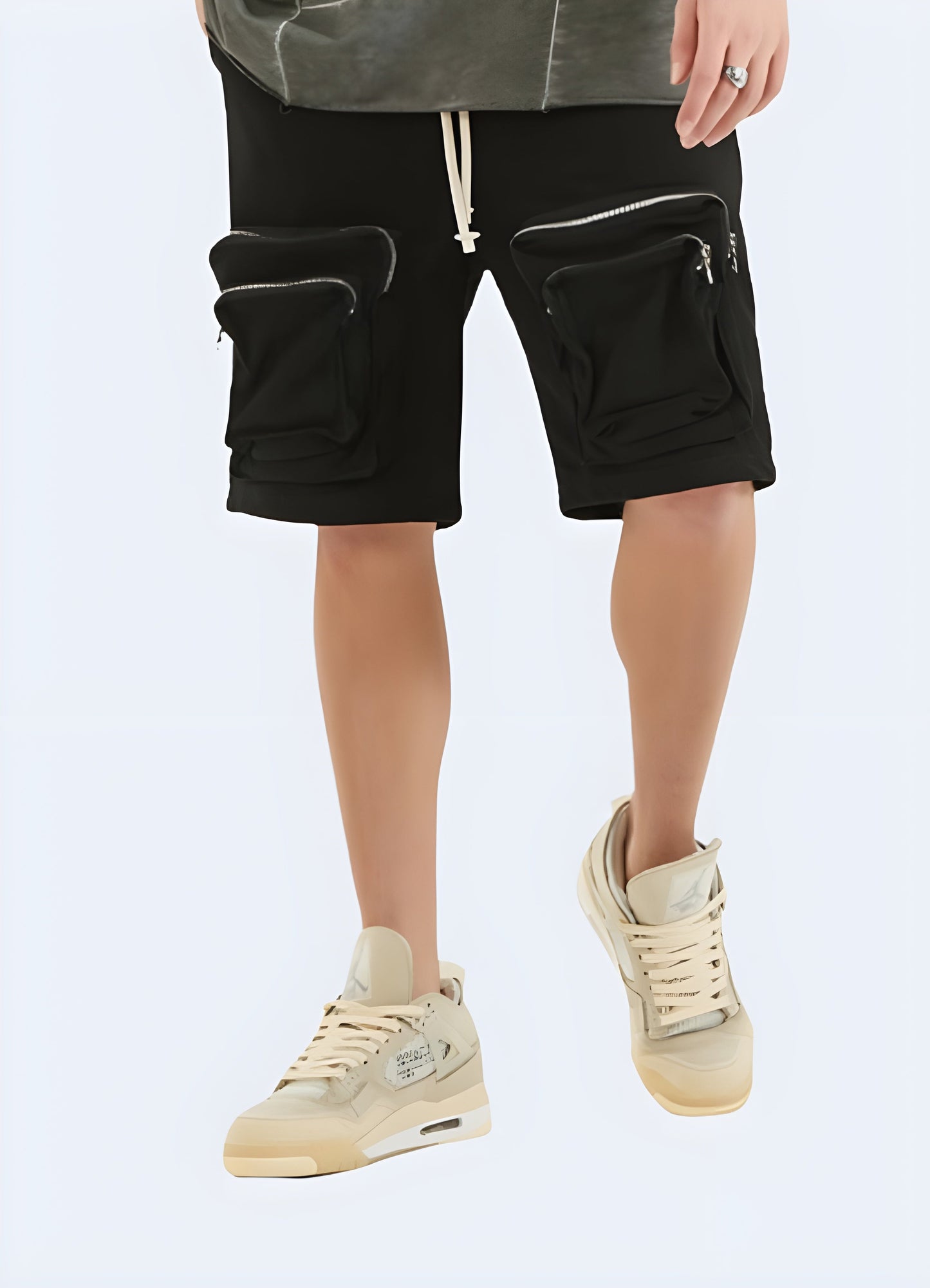 Man wearing black layered pocket zipper cargo shorts from the front view, highlighting the modern style and practical features, ideal for the fashion-conscious utilitarian.