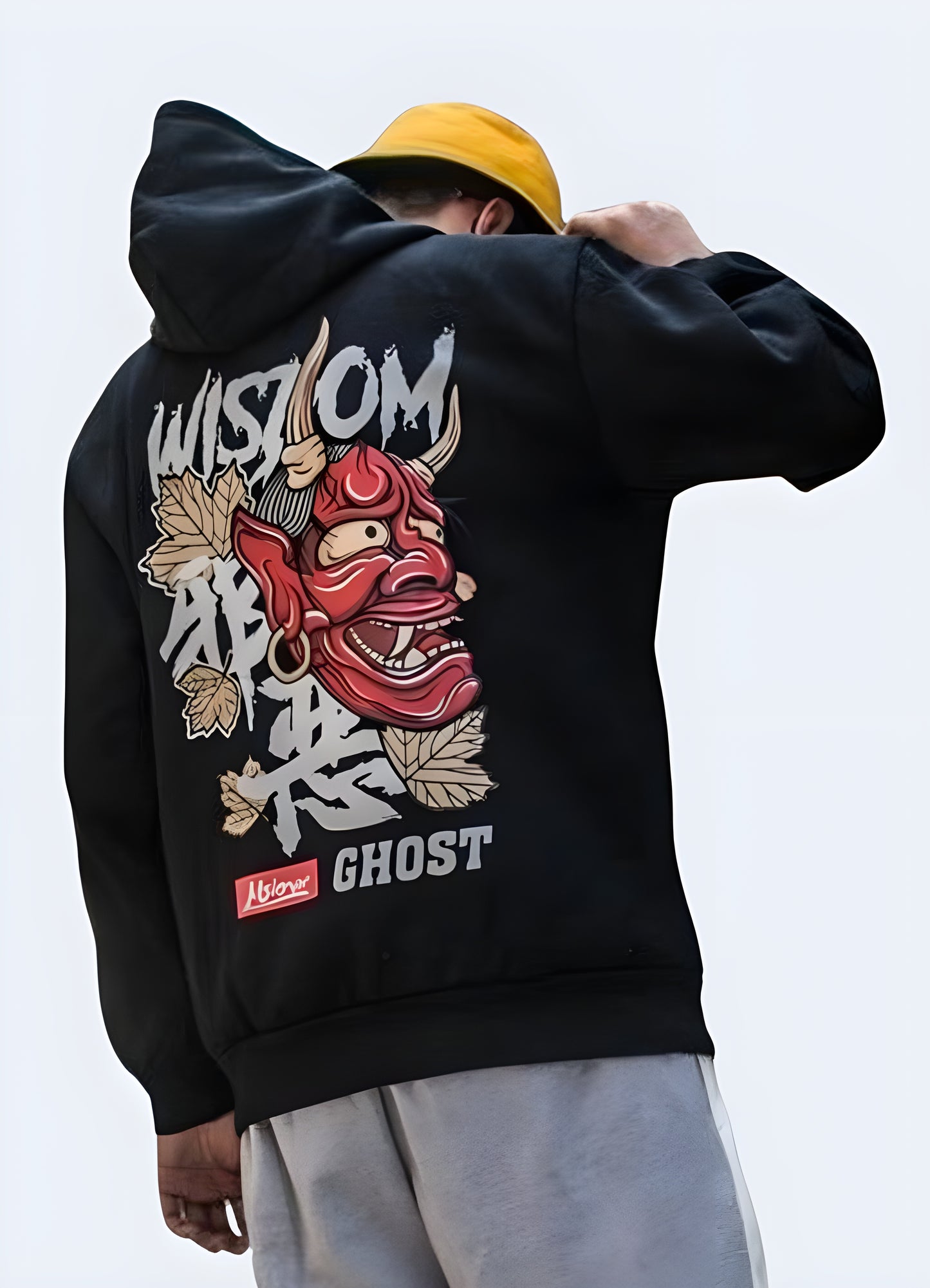 Back view of a man wearing a black hoodie featuring a large, red oni demon mask graphic.