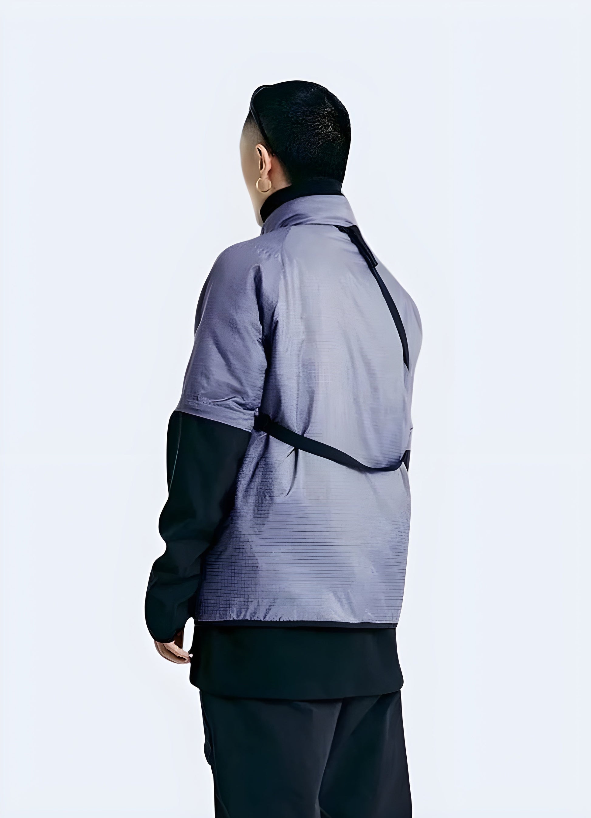 Man wearing a purple techwear jacket, showcasing the garment's unique back design and technical features, captured in the Canada.