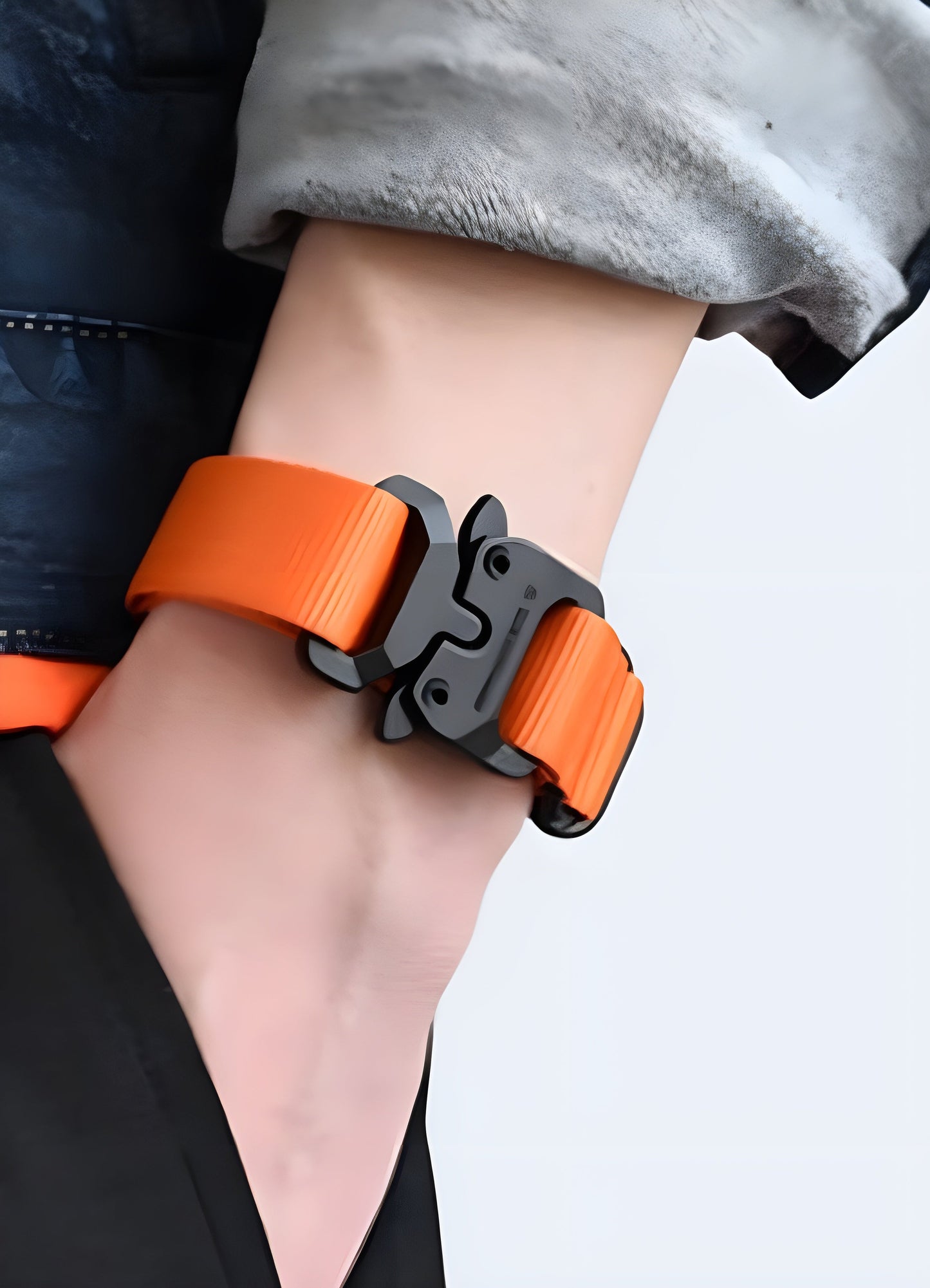 Man wearing a techwear buckle bracelet in orange, Canada, illustrating its vibrant and eye-catching design from the front view.