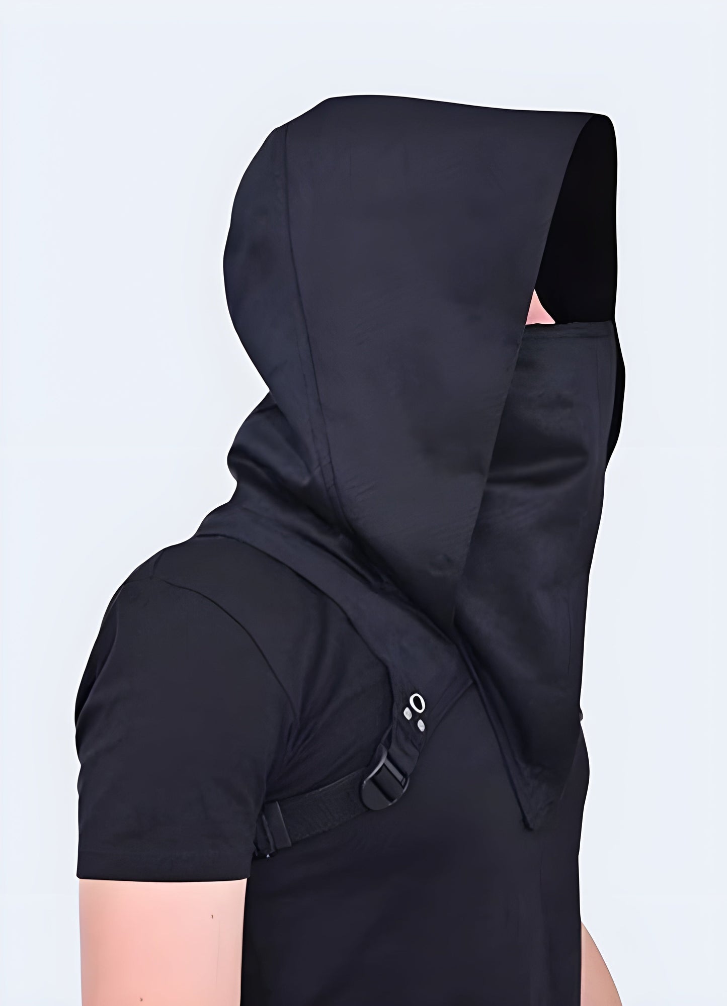 A man wearing a techwear scarf with a hood, captured in a side view to showcase the practical and stylish combination in the Canada.