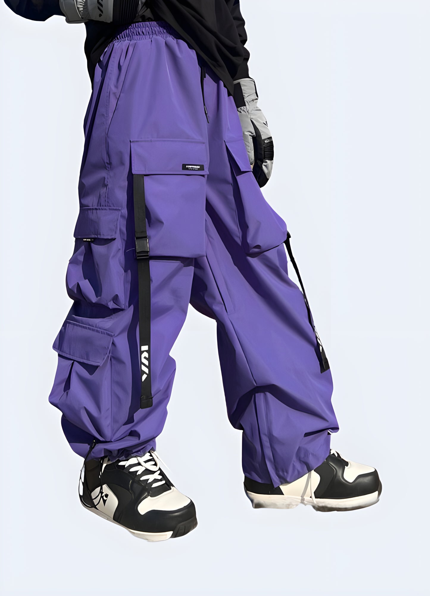 Man wearing techwear ski pants in vibrant purple, front view, highlighting their stylish and functional design, available in Canada.