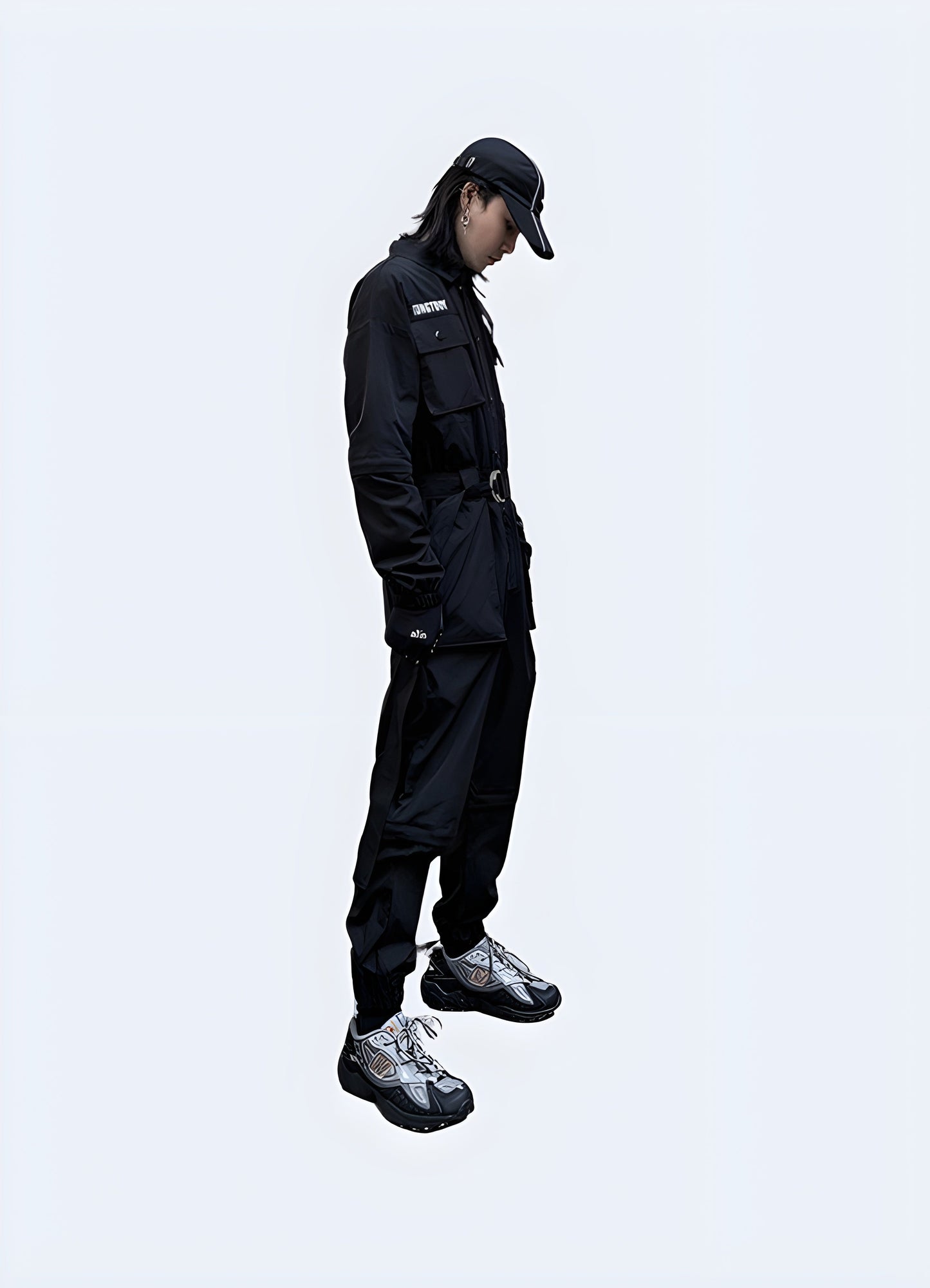 Side view of a man modeling cutting-edge black techwear workwear, highlighting the blend of functionality and style, perfect for modern professionals in urban Canada settings.