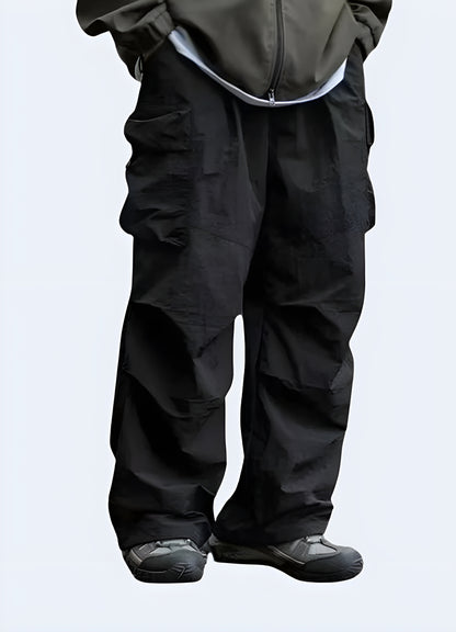 Men's fashionable black parachute pants with relaxed fit and drawstring waist, perfect for creating edgy streetwear outfits in Canada.