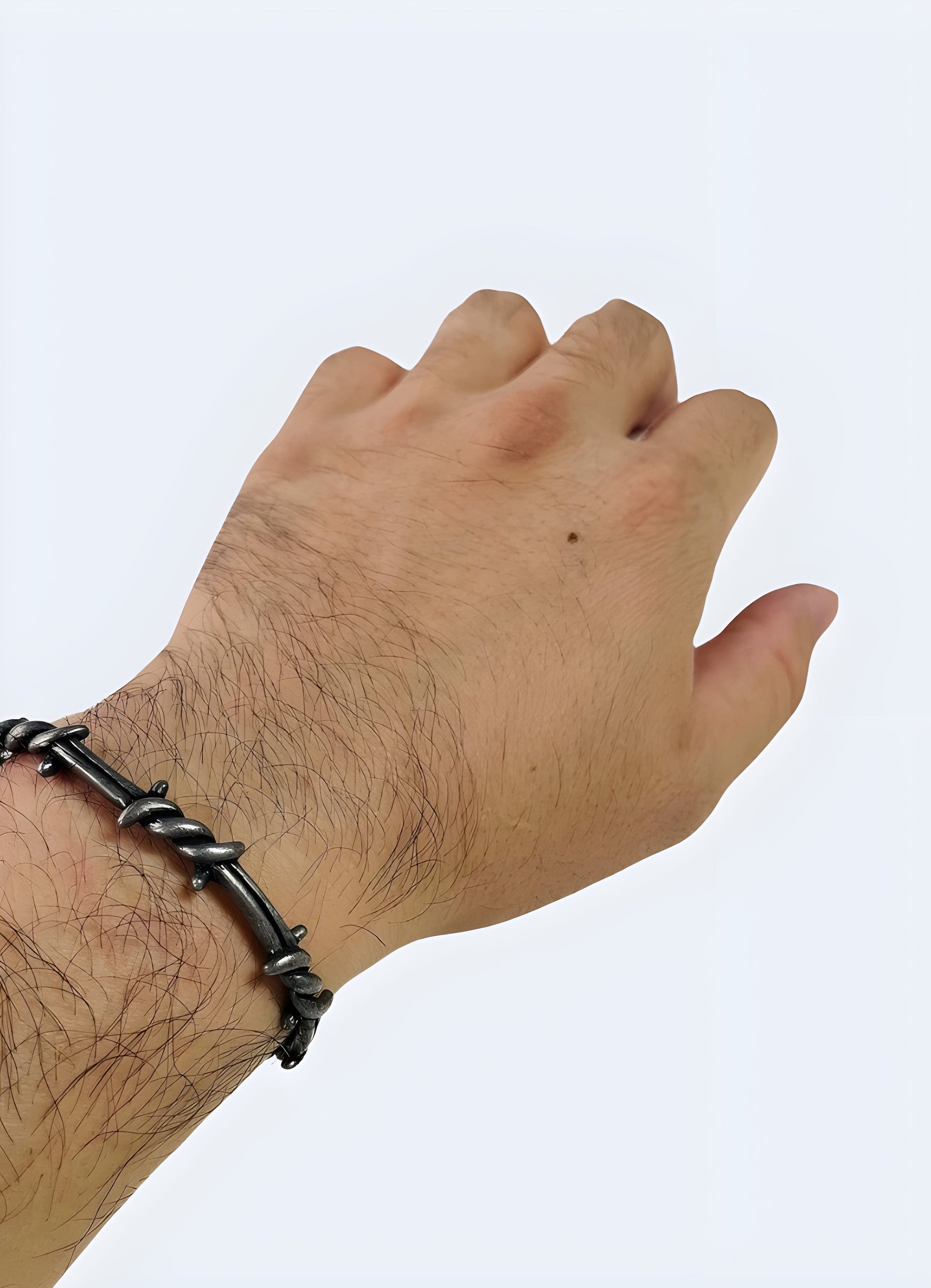 Man wearing a barbed wire bangle, shown from the front view, highlighting its detailed design and how it complements his outfit Canada.