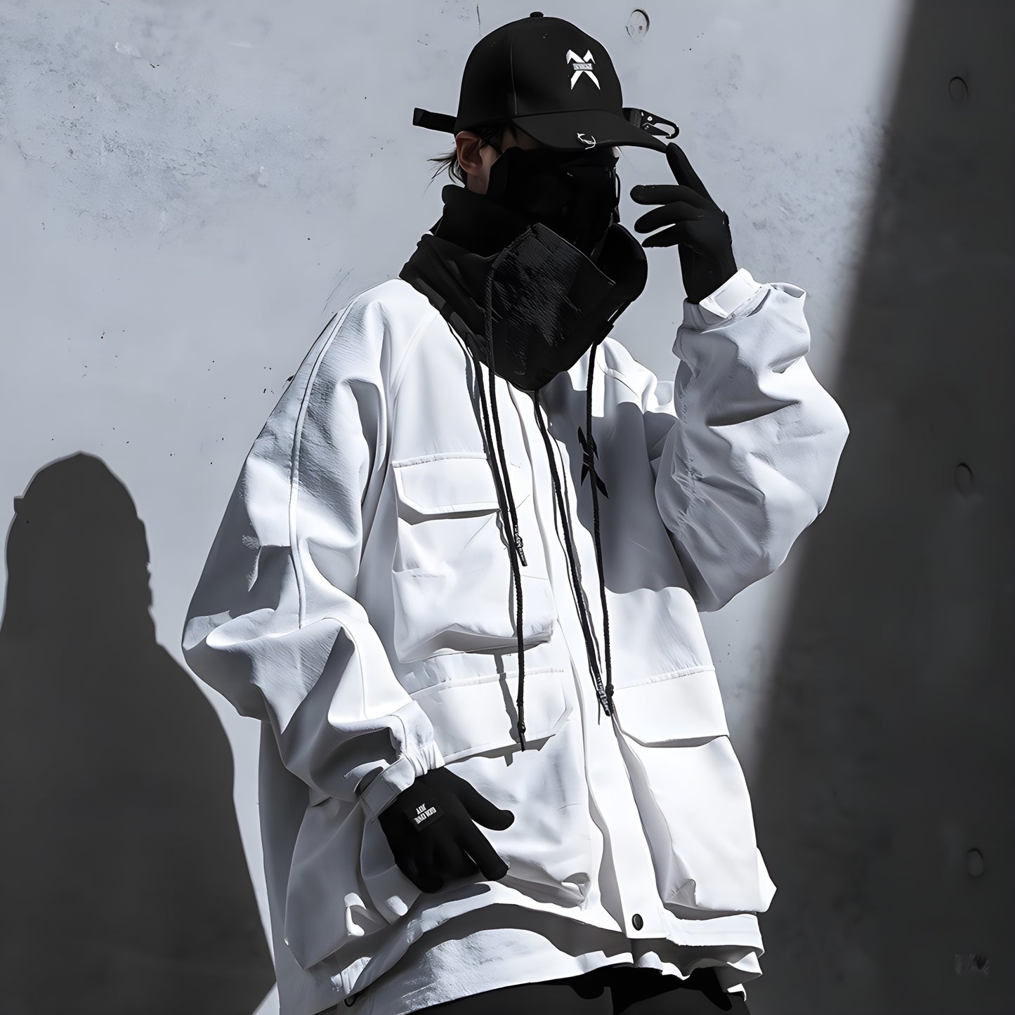 The design is sleek and minimalist, aligning with techwear style. The man’s face and the upper part of his torso are visible, emphasizing the garment's functional and modern aesthetic Canada.