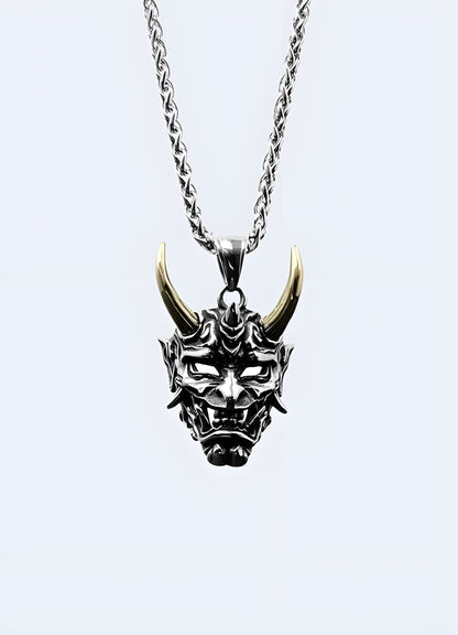 Gold oni mask necklace in a front view, Canada, highlighting its detailed craftsmanship.