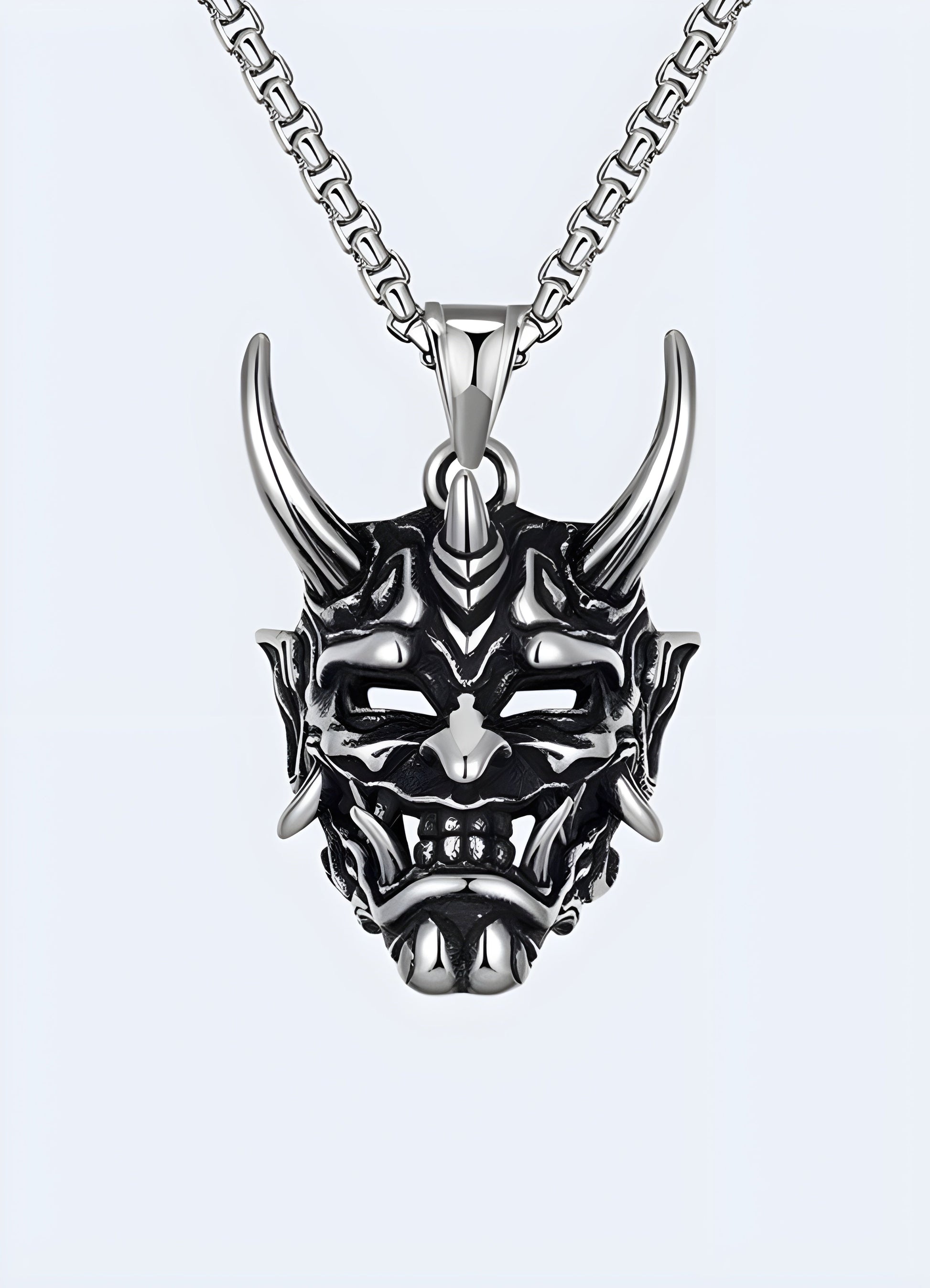 Silver oni mask necklace, Canada, with intricate design and bold statement.