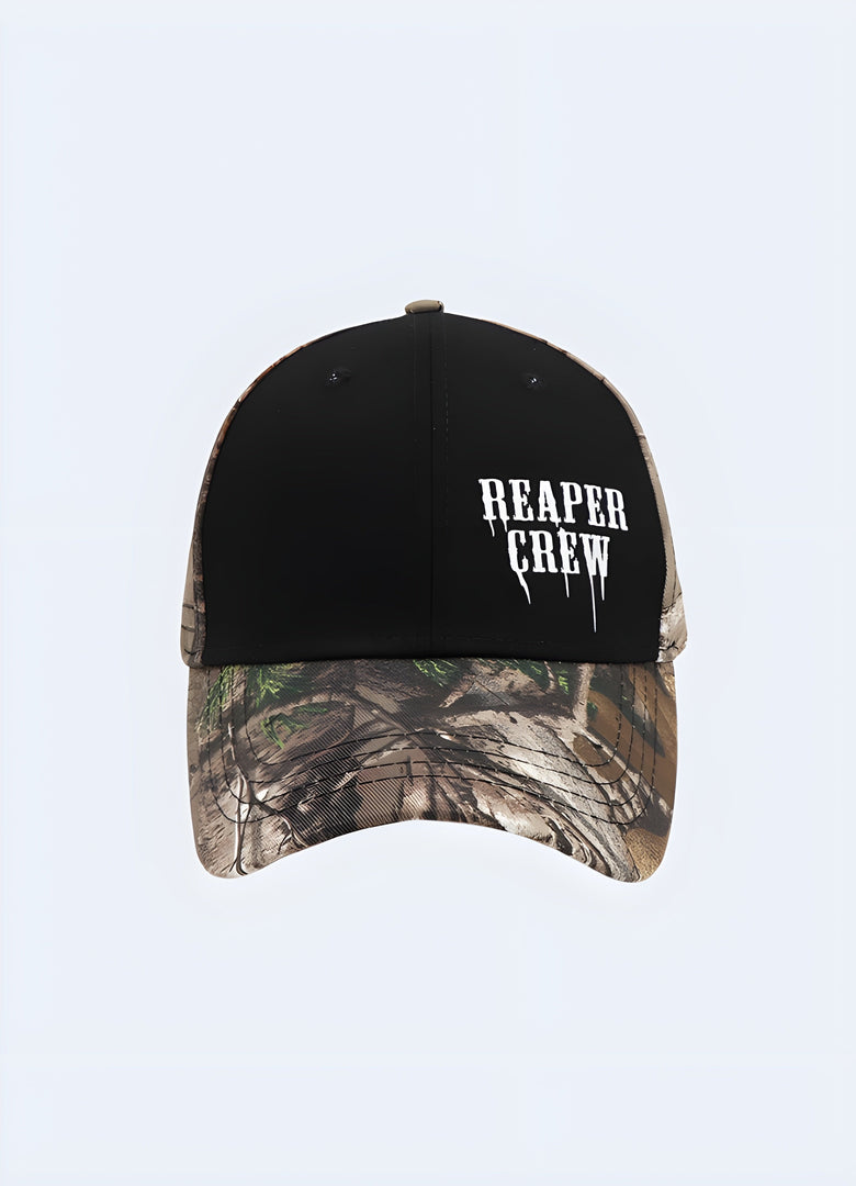A front view of a camo-patterned cap with "Reaper Crew" text emblazoned across the front panel in bold, contrasting letters.