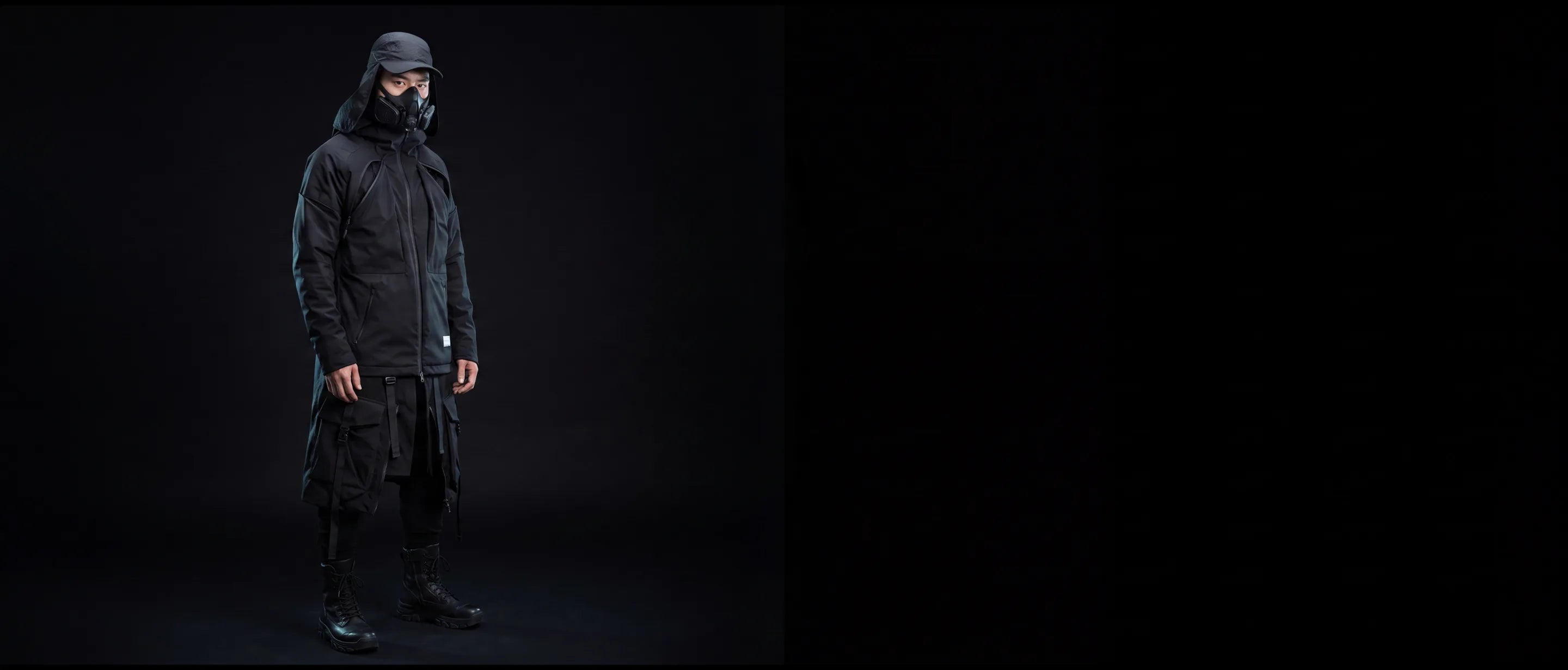Model in black tactical techwear jacket and respirator mask, dark studio, Techwear Canada new collection