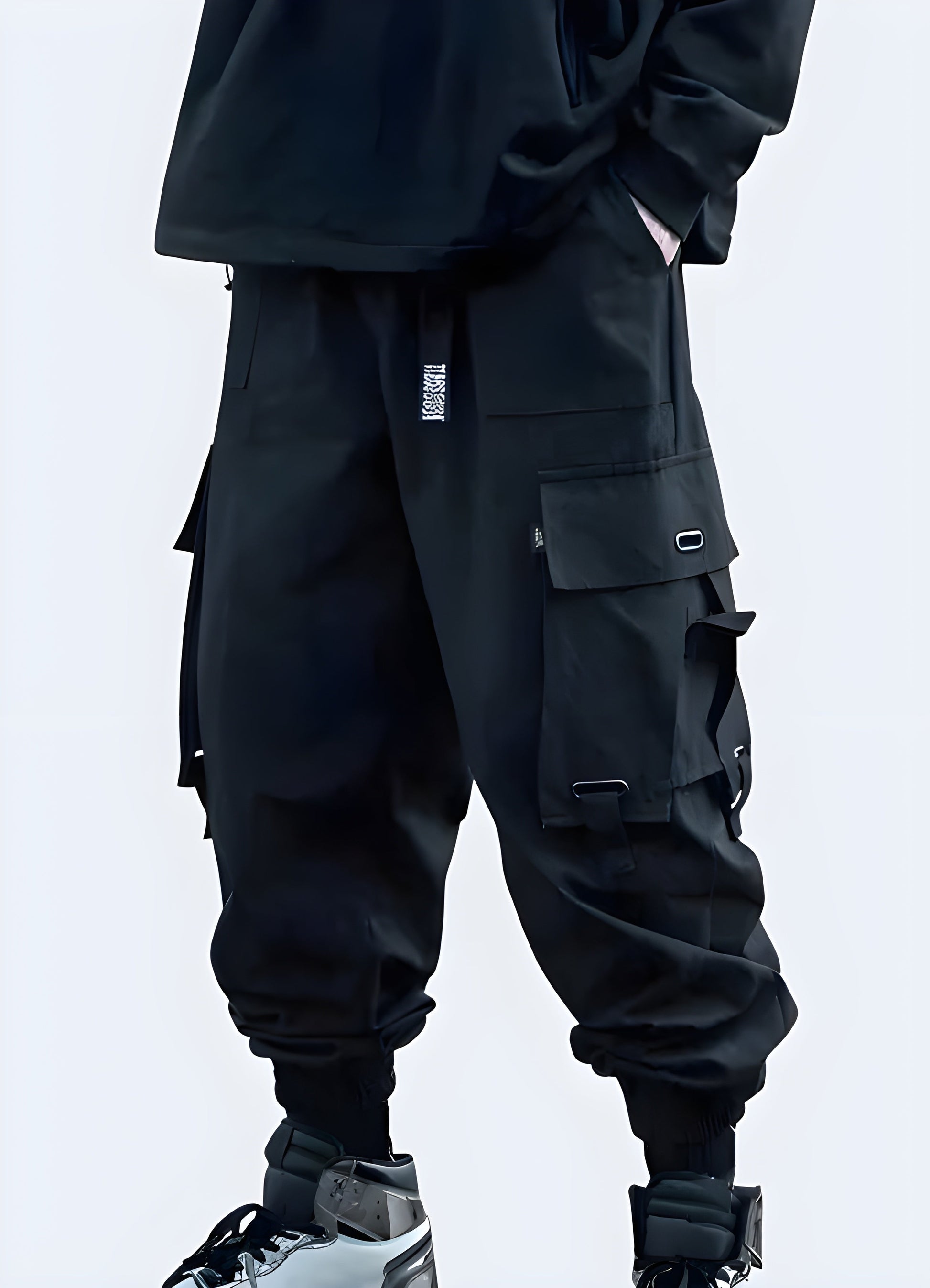 Side view of model in stylish black techwear cargo pants with utility pockets and tapered fit, Canada streetwear.