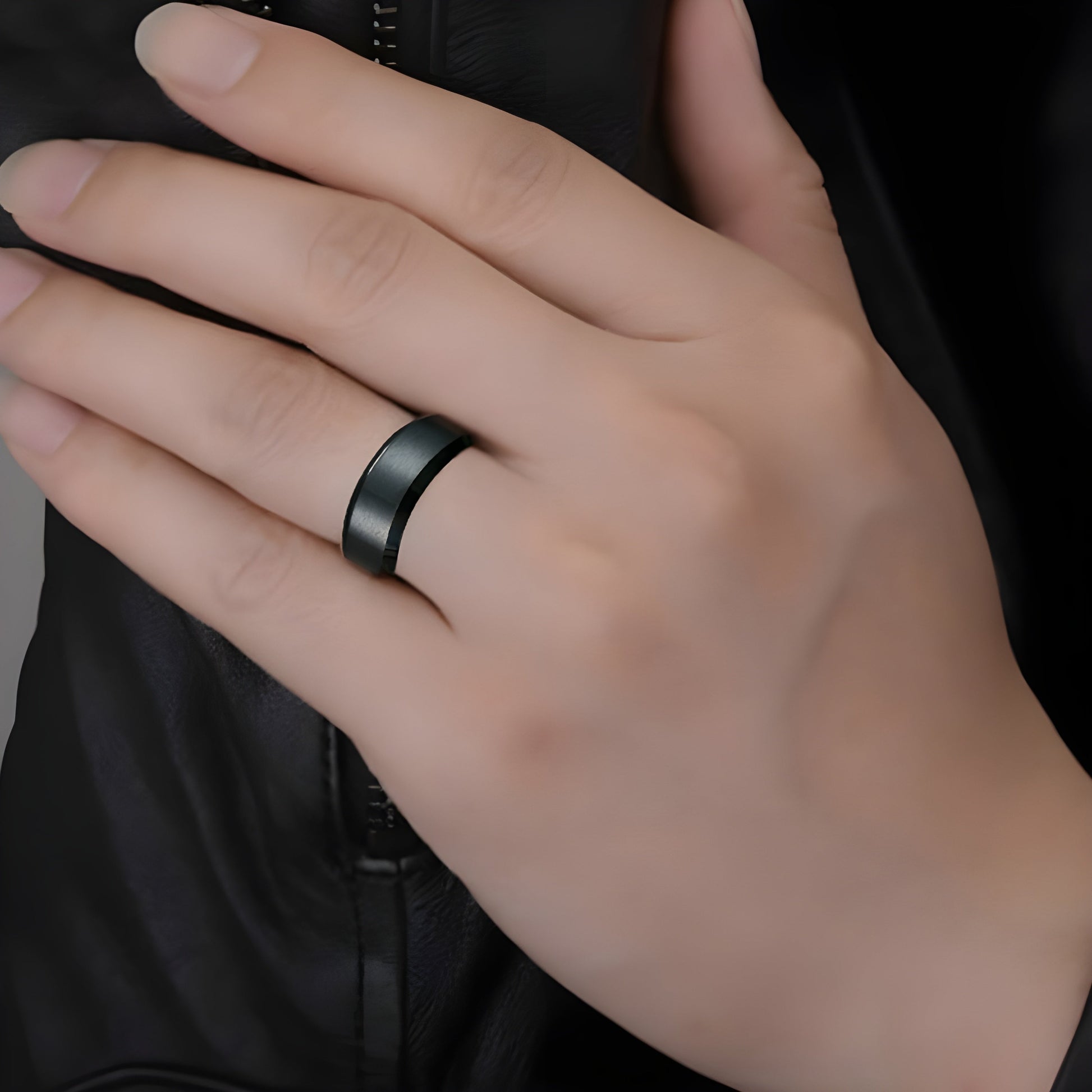 Person wearing a black titanium ring, Canada shown in a front view, highlighting the sleek and modern design of the ring.