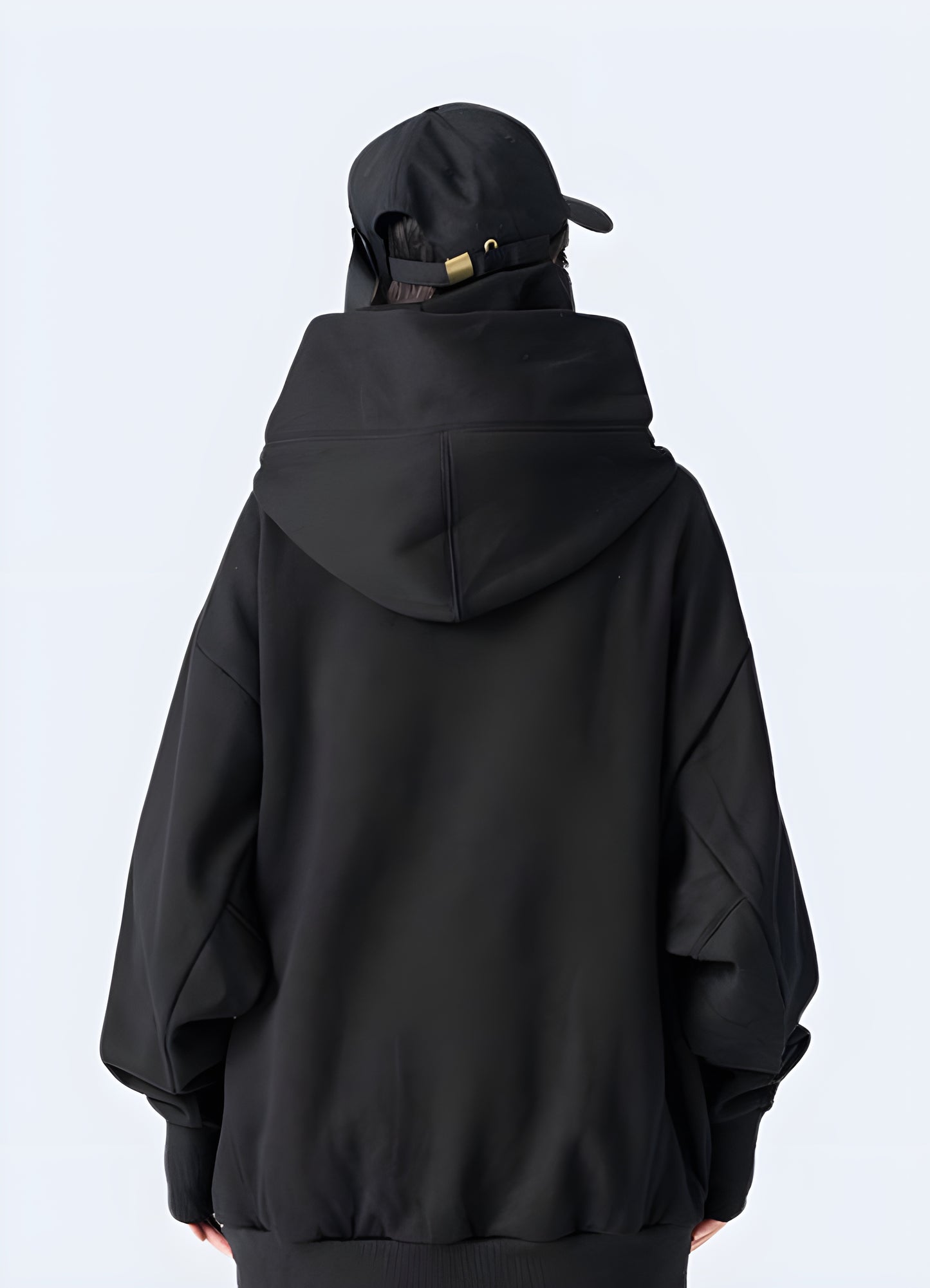 Woman wearing a black comfortable Harajuku hoodie, back view, in Canada. Showcasing modern streetwear style.