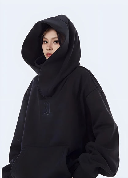 Woman wearing a black cotton women's techwear hoodie, side view in Canada, emphasizing its sleek and modern look.