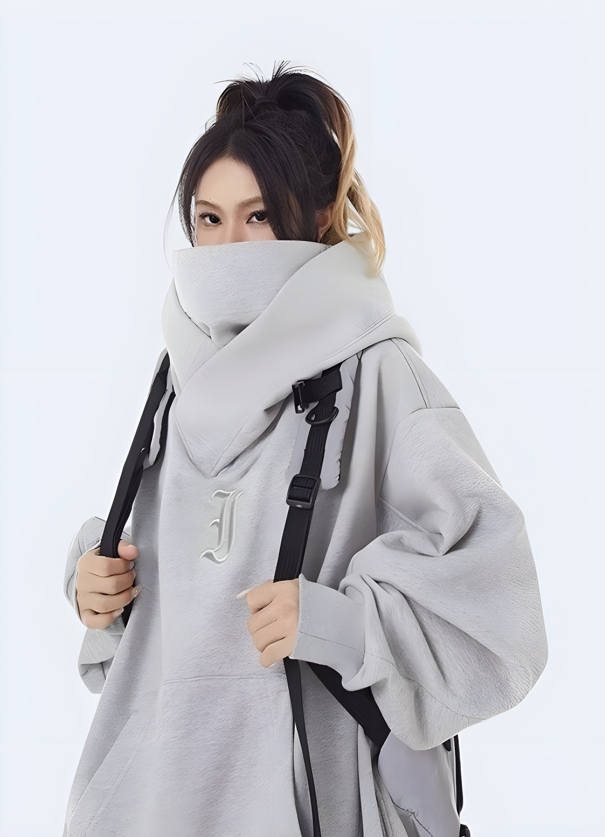 Woman wearing a grey cotton women's techwear hoodie, side view in Canada, highlighting its stylish and comfortable design.