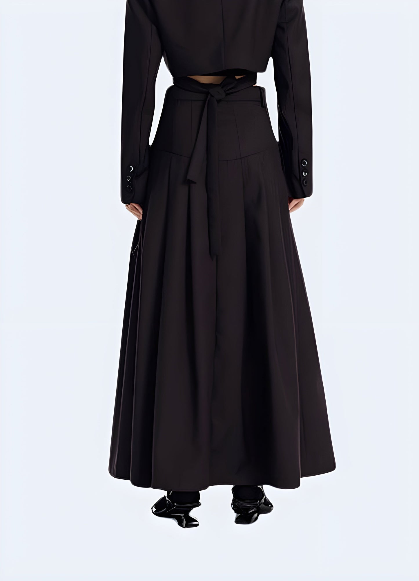 Back view of a woman modeling an elegant techwear skirt, showcasing the refined design, premium fabrics, and sleek silhouette for a chic urban aesthetic.