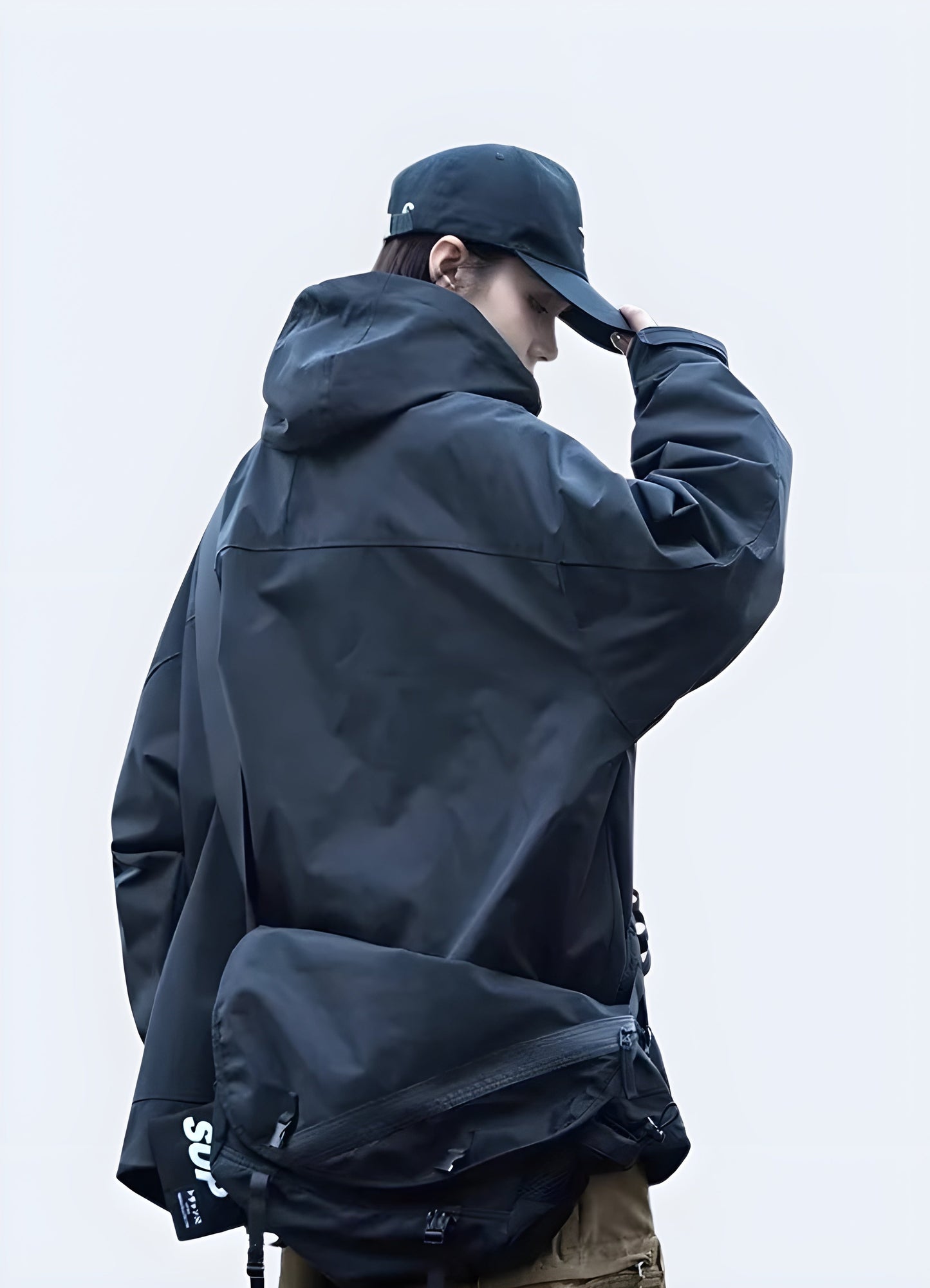 Back view of a woman wearing a techwear cargo jacket, showcasing its practical storage options and modern aesthetics for city life in the Canada.