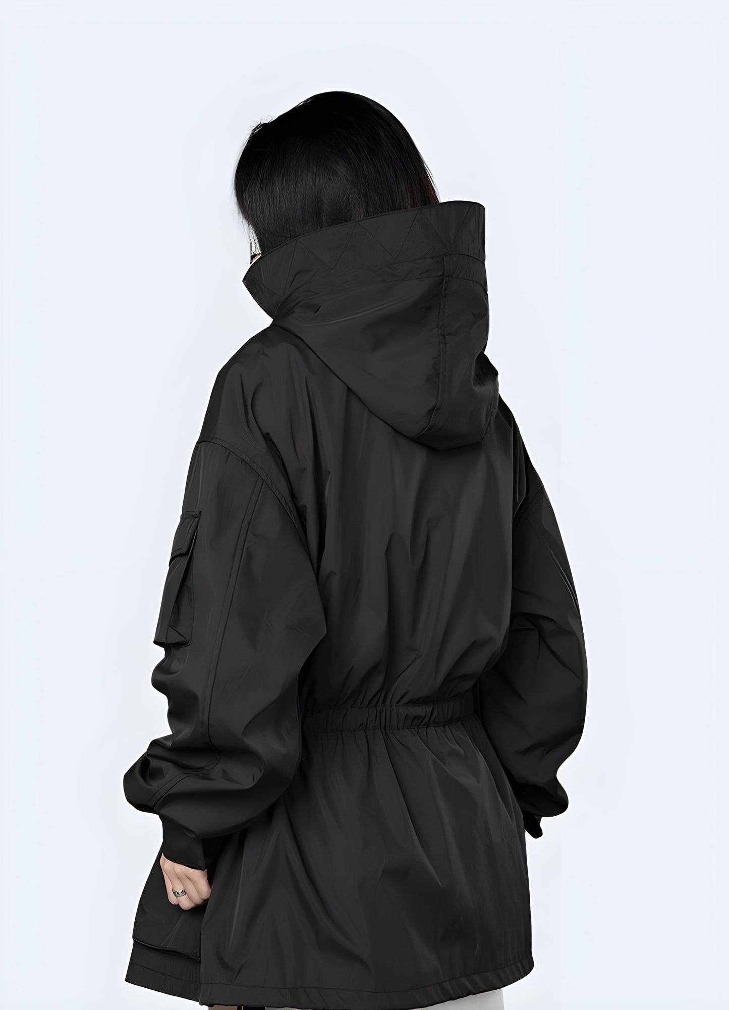 Back view of a woman wearing a women's techwear parka, showcasing its functional features and modern silhouette for city life in the Canada.